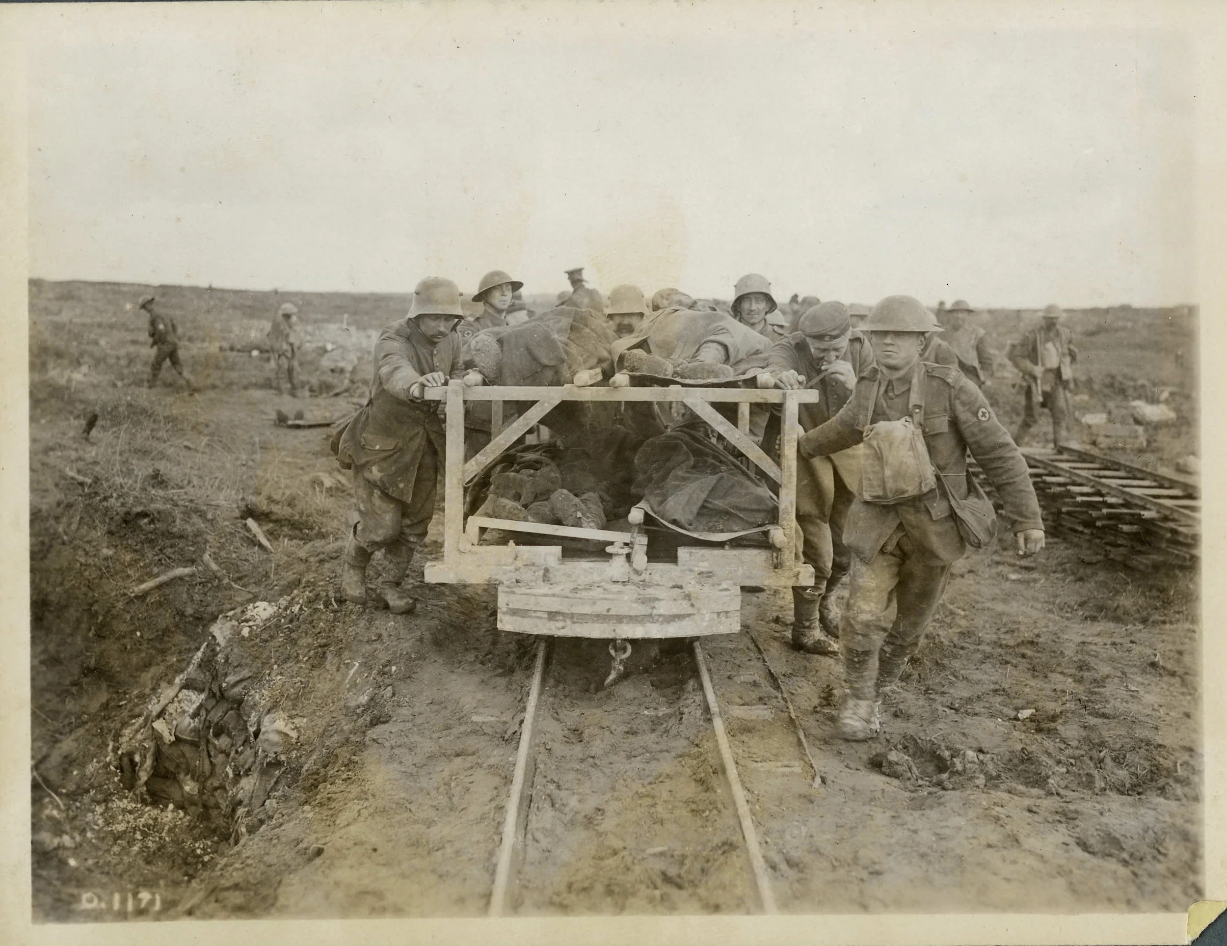 Canadian medical officers (with the Red Cross emblems on the soldiers at right and to the left rear of the photo) use German prisoners, destined to captivity, to help transport Canadian casualties from Vimy Ridge, April 1917. They use a two-tiered c…