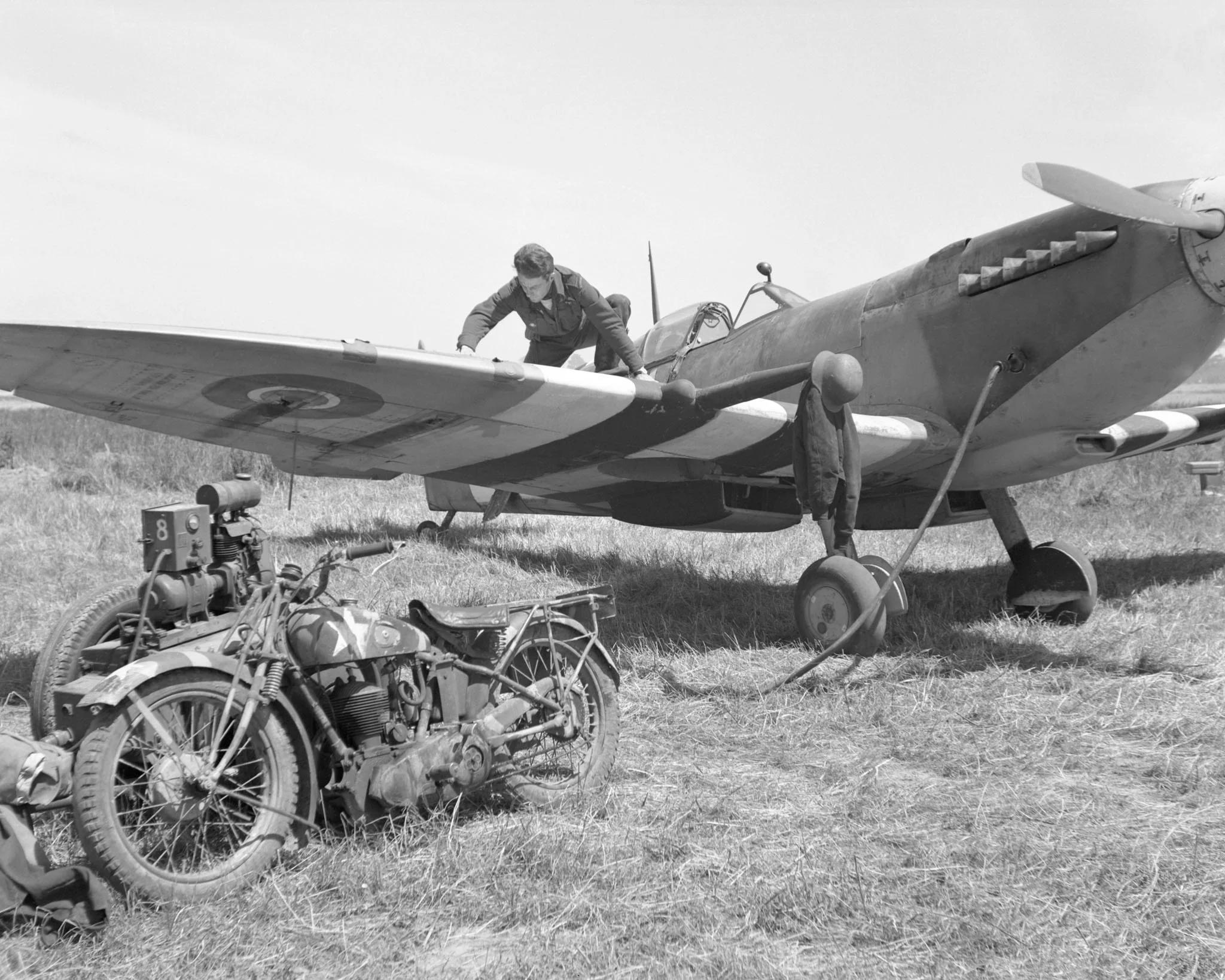 The original caption of this photo, taken on June 8, 1944, reads: “a captured German helmet over the muzzle of his cannon and a German motorbike obtained on a visit to the front line are now the property of Flying Officer H.W. ‘Bud’ Bowker [of] Gran…