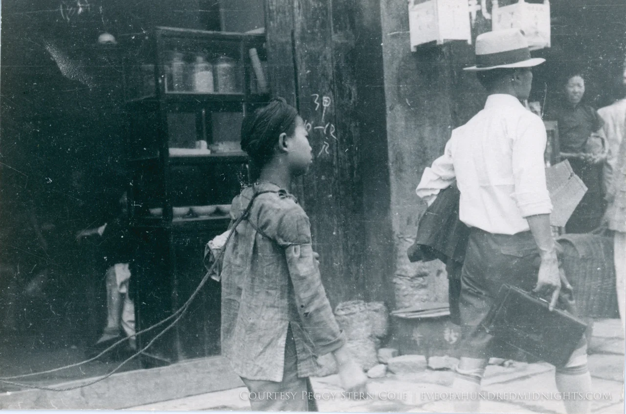 Boy with ropes tied to back on sidewalk.jpg