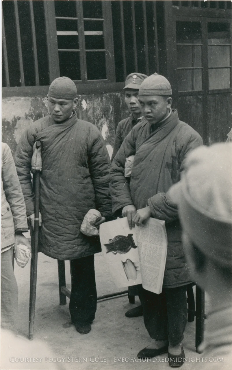 Wounded amputee and man with cross gown paying attention to something.jpg