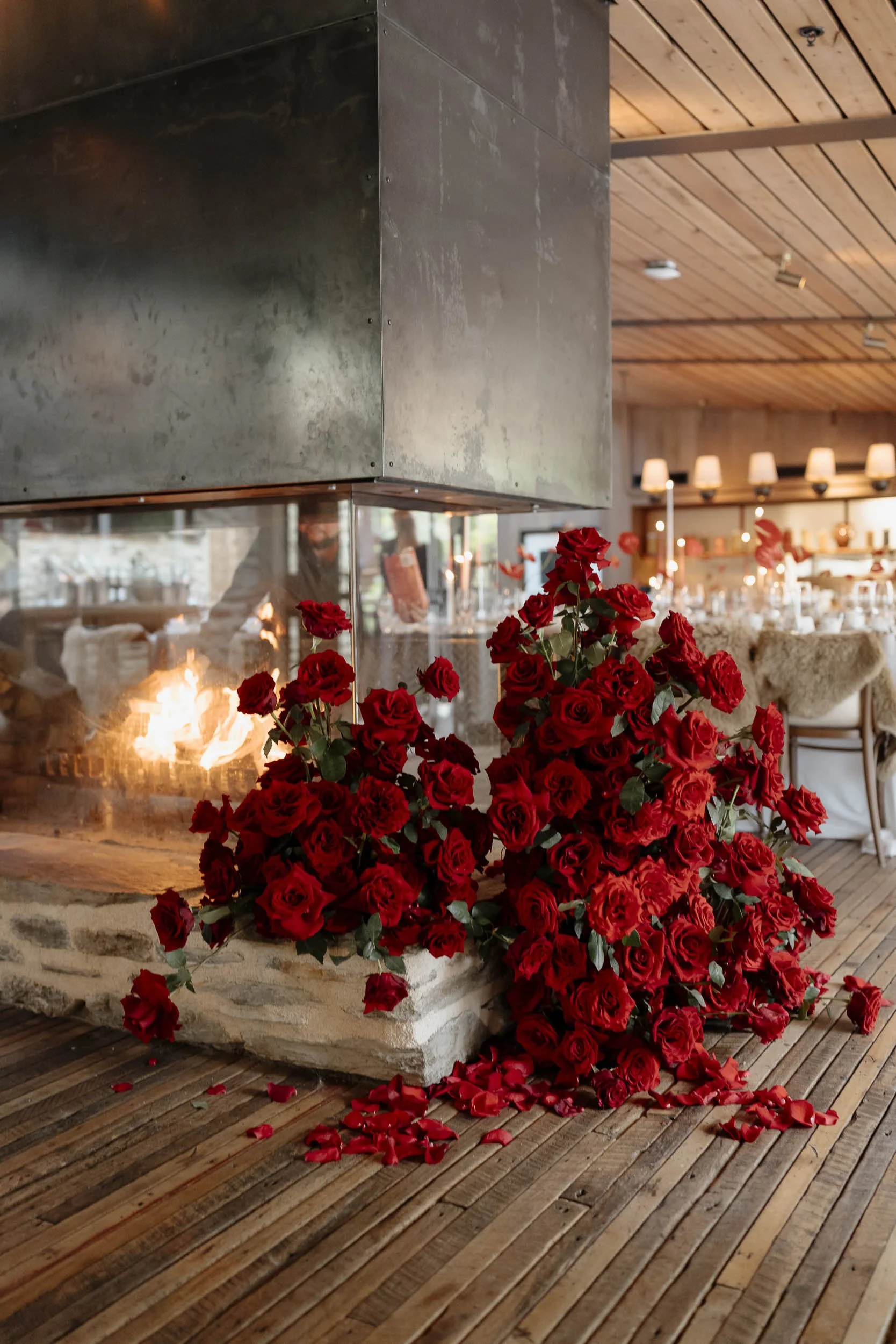 Large display of Red Roses laid next to a fireplace during a valentines day wedding in Queenstown, New Zealand