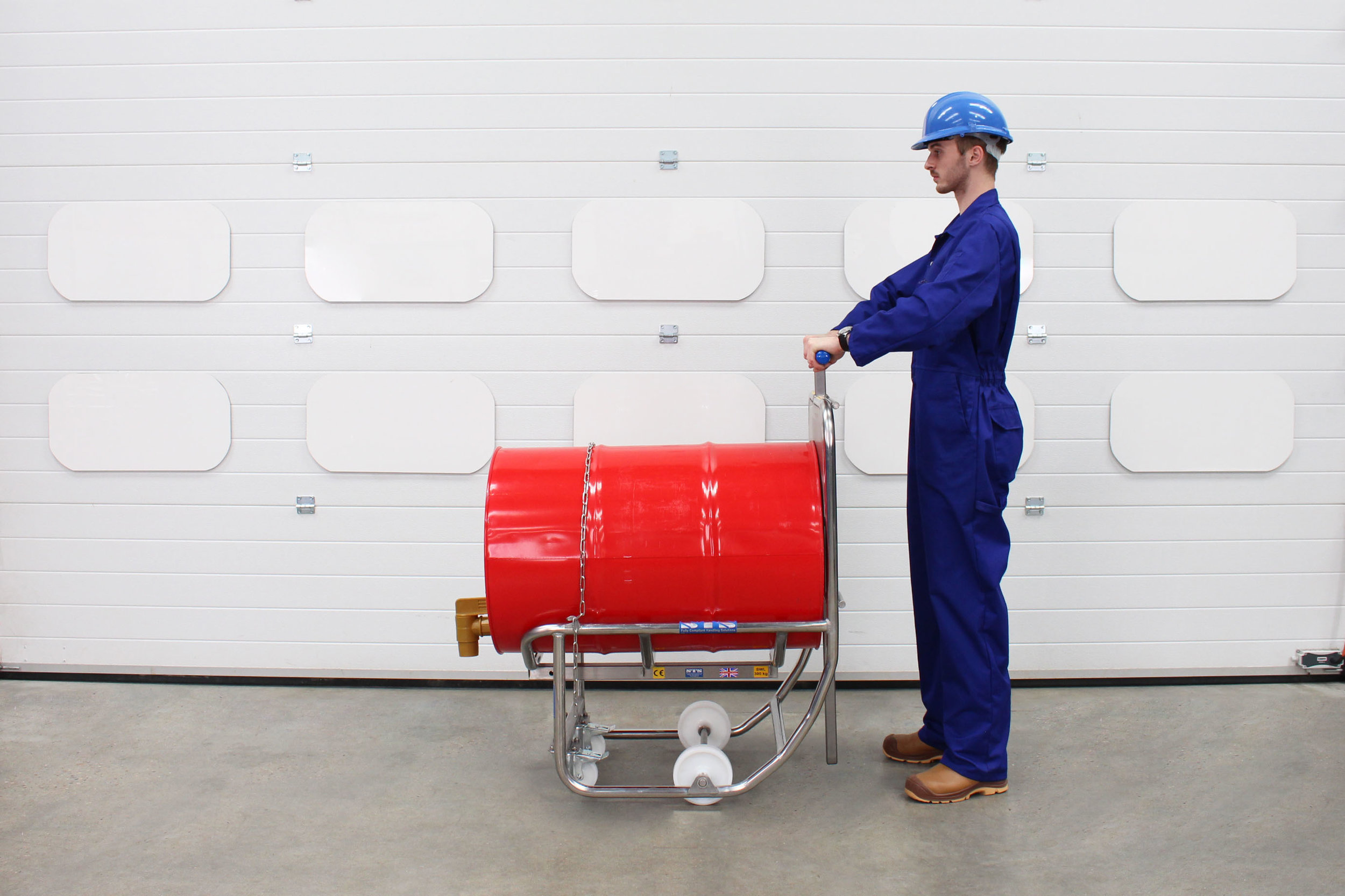 Operator stand at the rear of the drum and barrel dispensing cradle and pushes a drum using the handle..