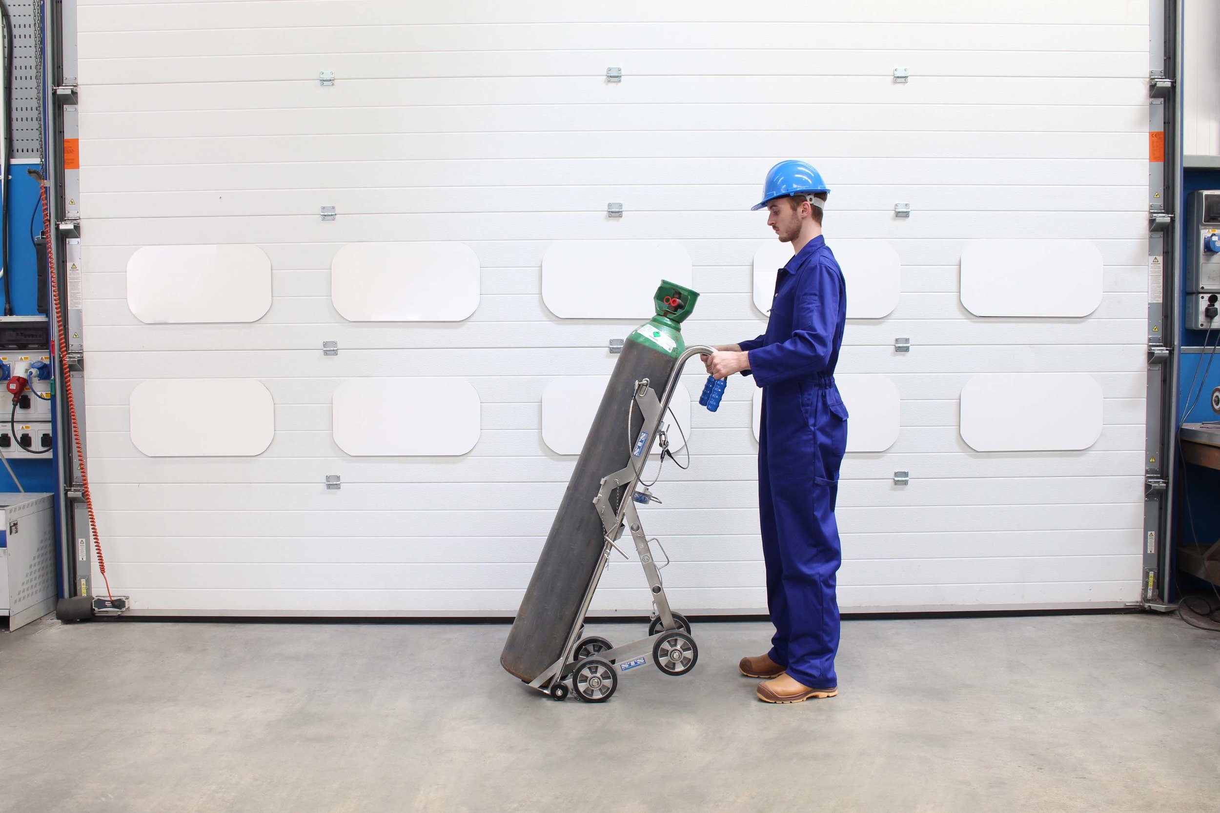 Operator secures a cylinder in the Gas Cylinder hand truck with Lifting Hoist 