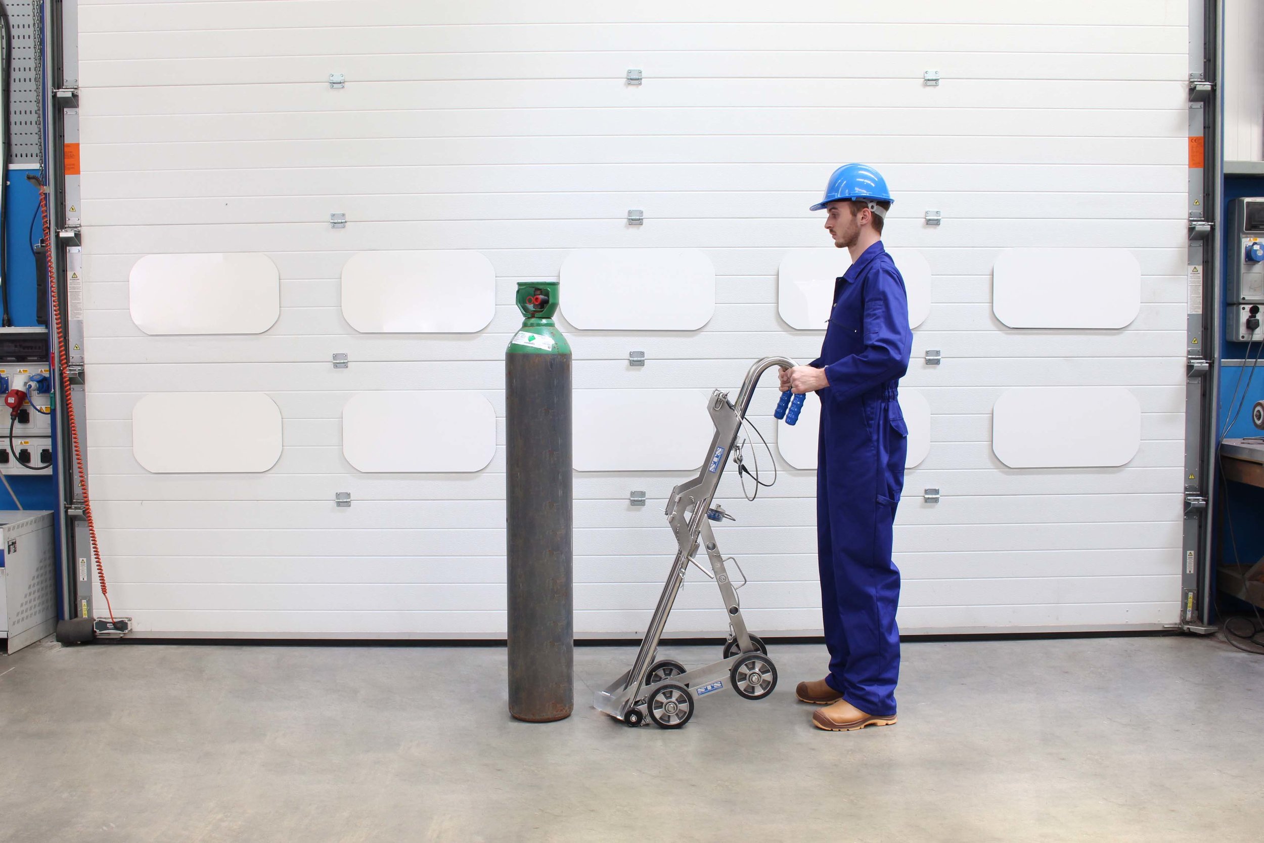 Operator approaches cylinder with a Gas Cylinder hand truck with Lifting Hoist 