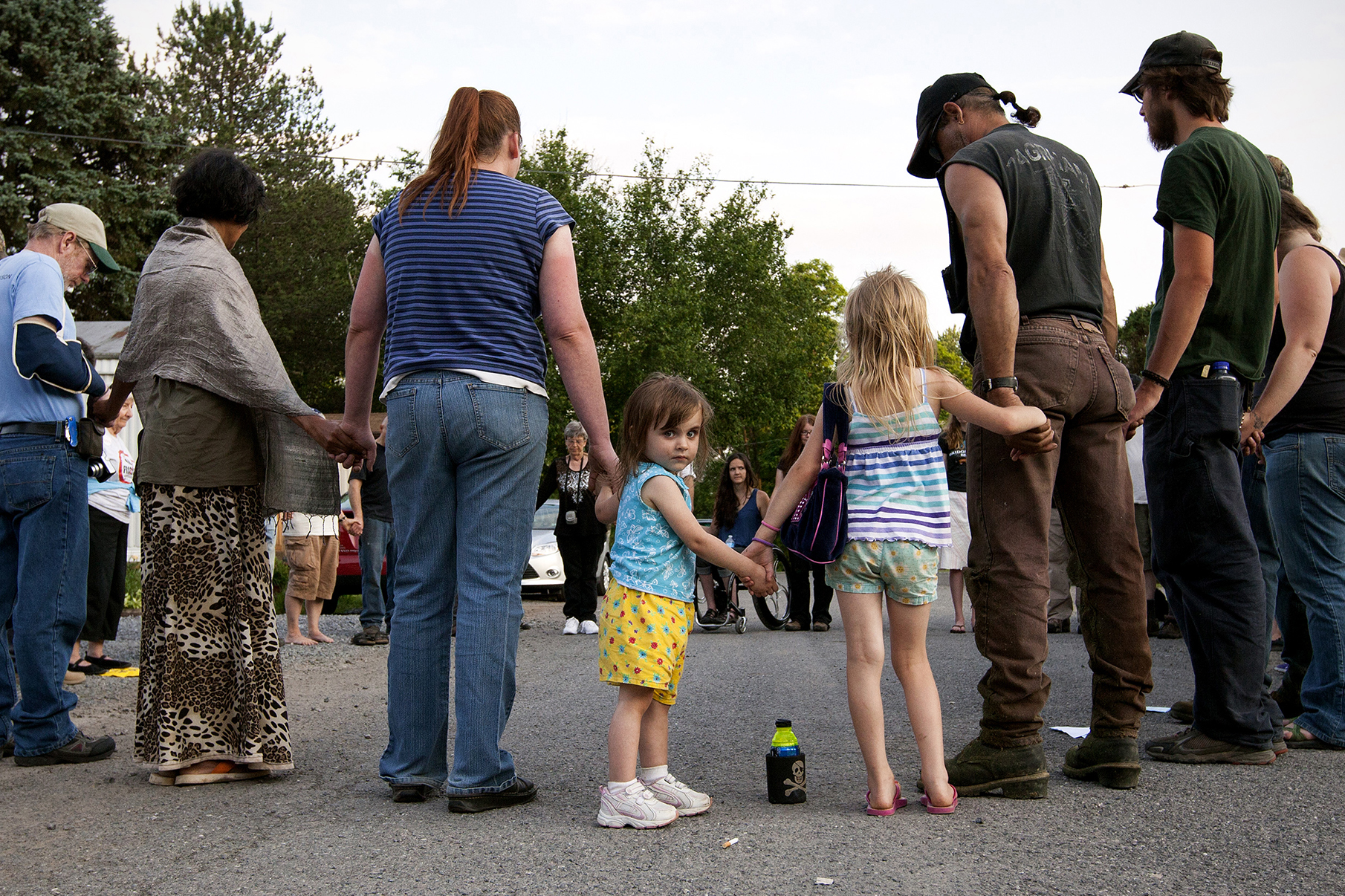 Residents and volunteers join hands to pray for the families that were forced to leave and the residents that have nowhere to go, Riverdale Mobile Park, Jersey Shore, PA.