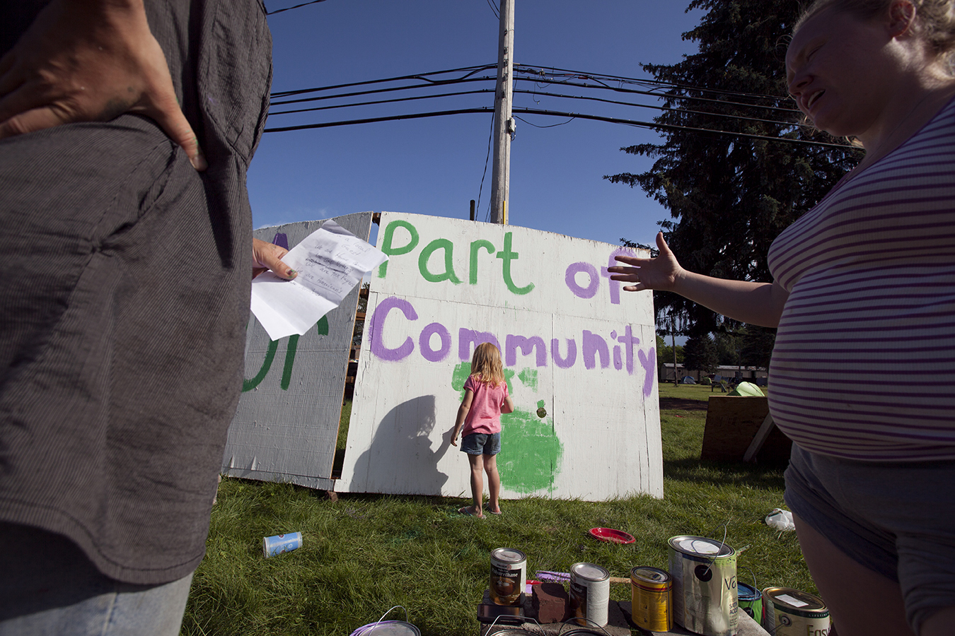 Jeanna, 4, helps her mother and an anti-fracking activist paint signs in front of Riverdale Mobile Park. A few weeks before the eviction, "fracktivists" arrived on the property and set-up camp. They wanted to help the remaining residents and try to
