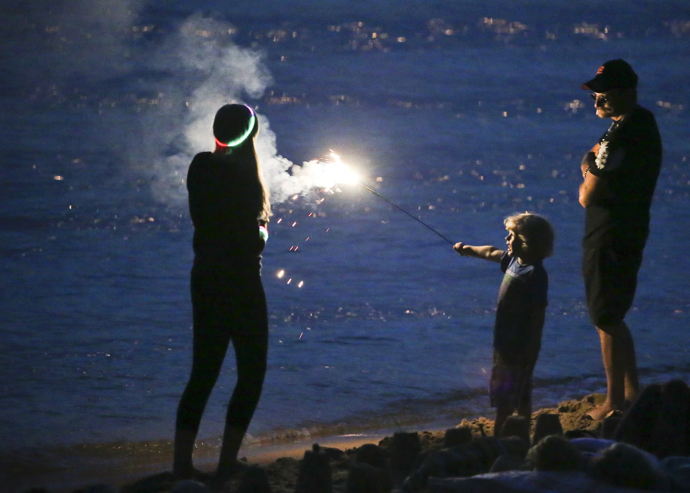 Sparklers are lit on South Haven Beach before the "Light Up the Lake" fireworks show in South Haven, Michigan. 