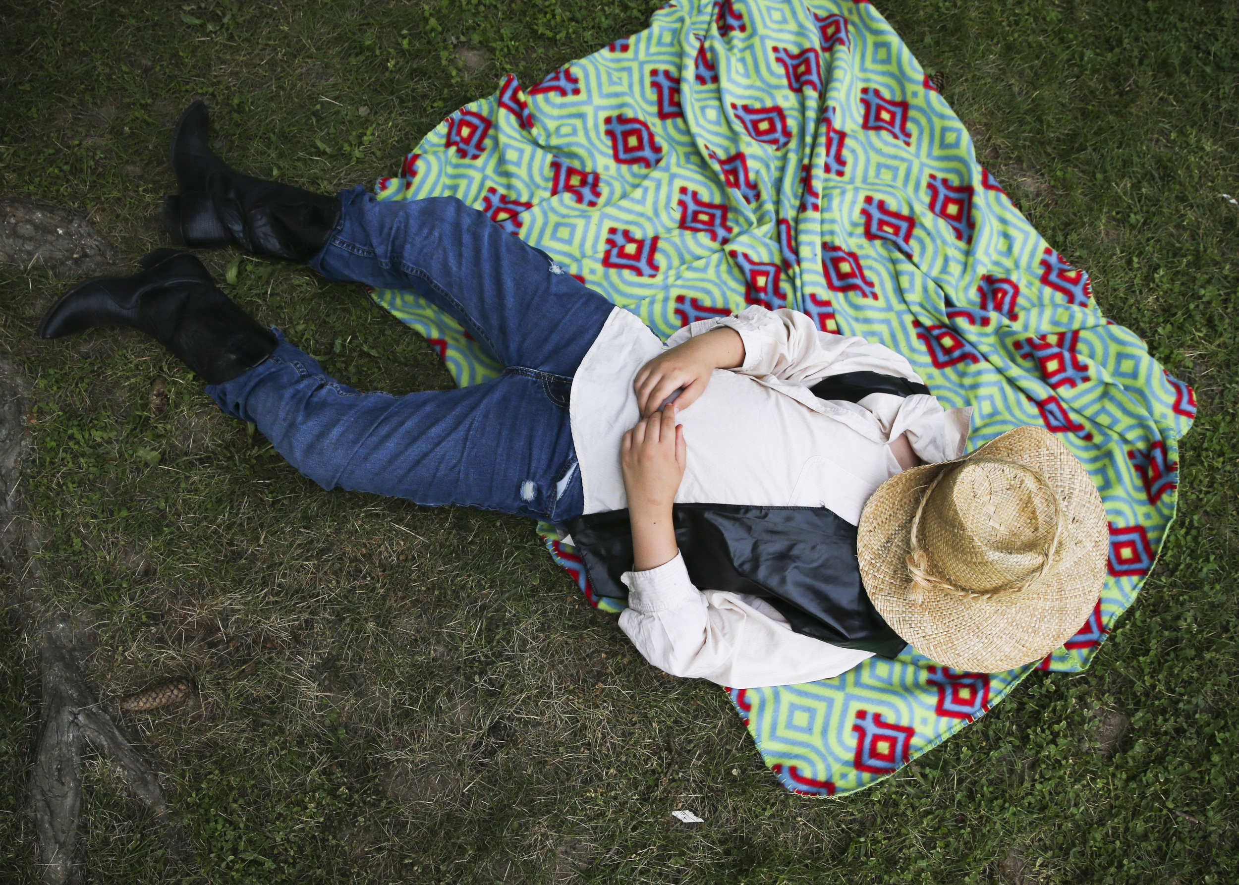 Actor Holden Lance, 11, takes a moment to rest between scenes of "The Ballad of Jessica James" during the Kindleberger Summer Festival at Kindleberger Park in Parchment, Michigan.