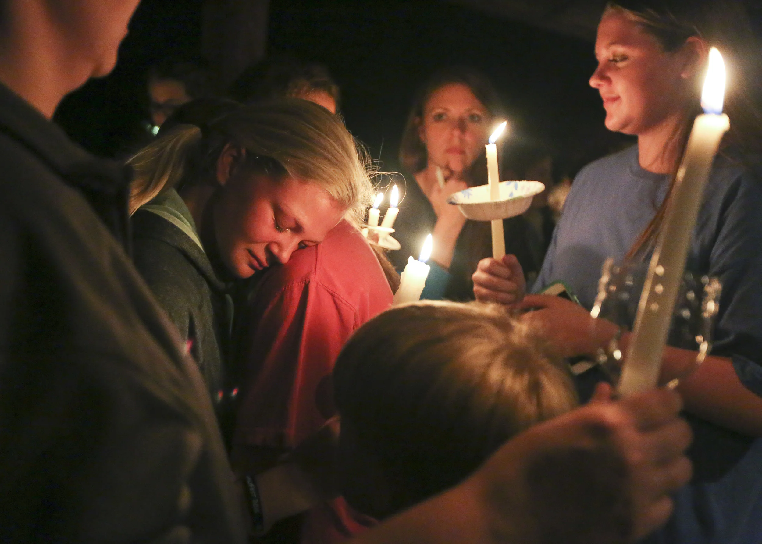  Brynna Stepp, left, is comforted by a friend during a candlelight vigil at Sparkman Park in Hartselle, Alabama. The vigil honored several Morgan County teenagers who died over the span of a few months. 