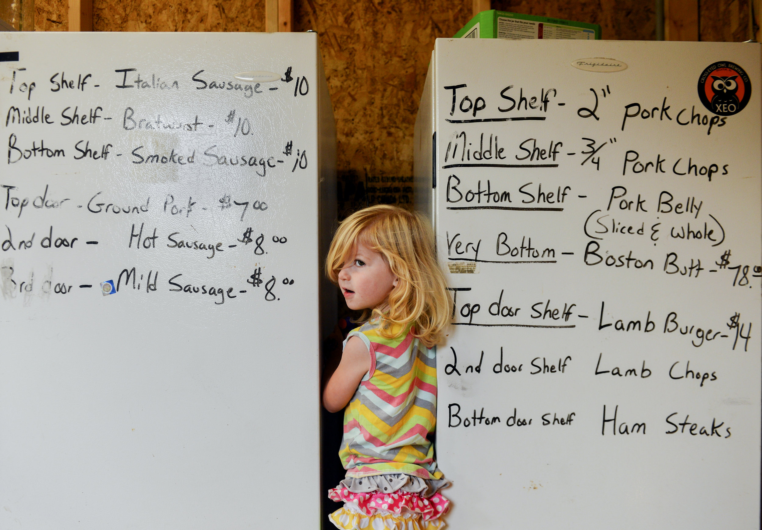 Raven stands between the meat refrigerators in the family's small store that sits next to their home. Through the daily chores, the girls are learning responsibility, work ethic, and about the food they eat. “They are learning where everything comes from,” Jessica Murphy said. “There are some people who will eat chicken from a fast-food restaurant, but not the chicken we sell. The picture of a whole chicken being cooked in households isn’t as normal as it used to be. A lot of kids don’t grow up seeing a whole chicken. They are seeing a breast or a leg or chicken nuggets.”