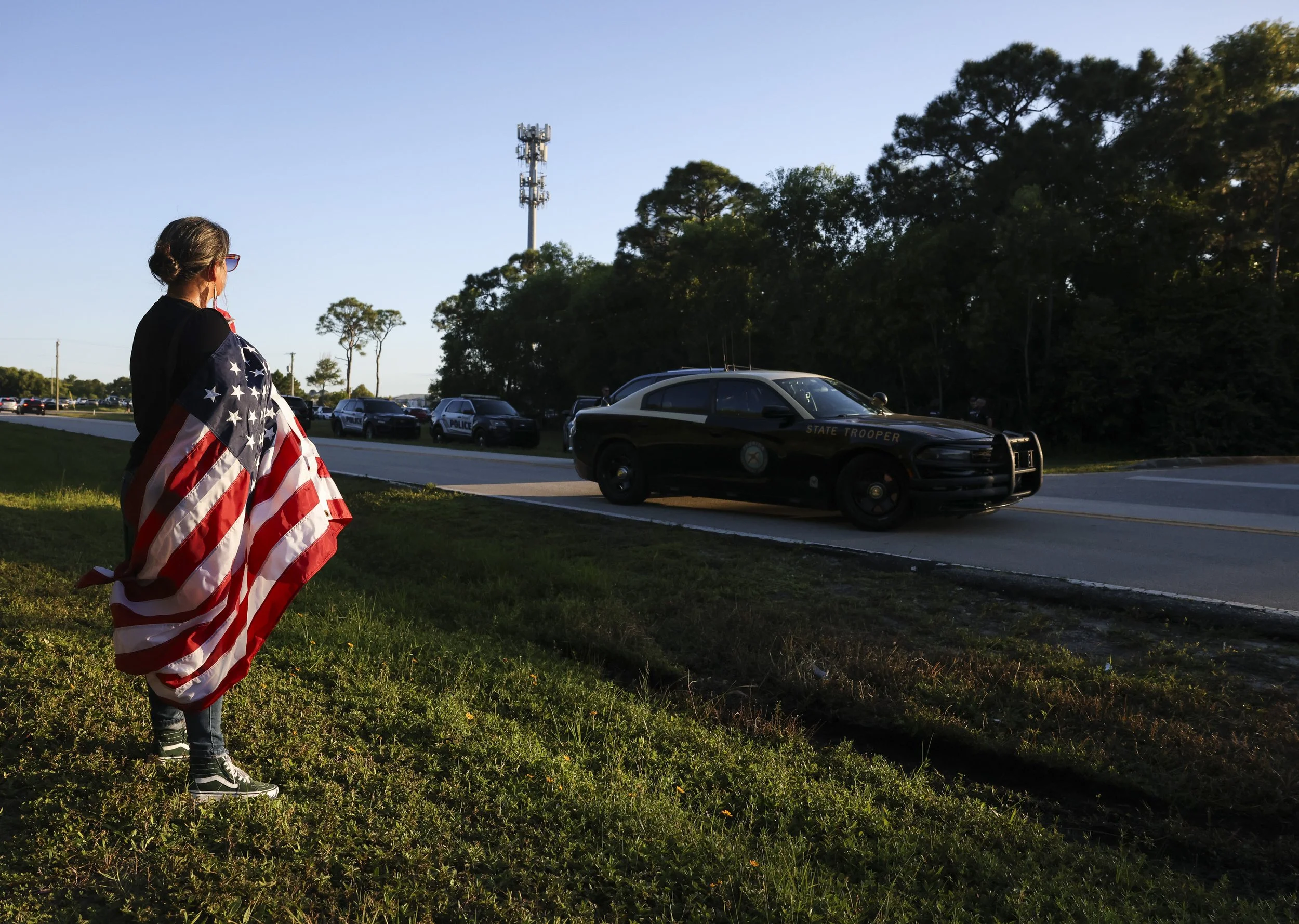  Anti-ICE protester is wrapped in an American flag in front of the ICE facility, Oct.. 22, 2025, in Stuart. Authorities are carrying out hightened immigration enforcement on the Treasure Coast this week, particularly in Martin County, according to st