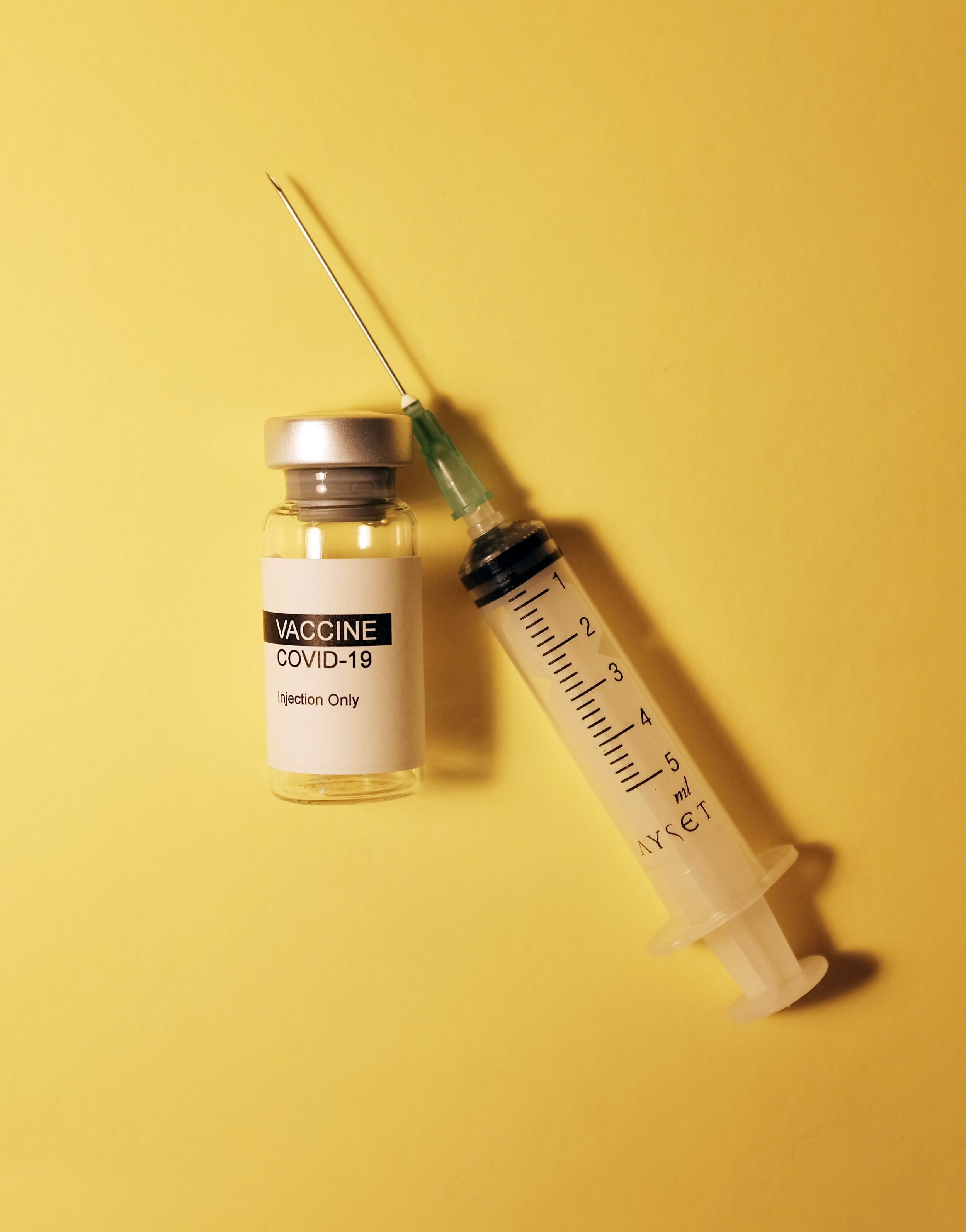 COVID-19疫苗瓶和注射器的照片。