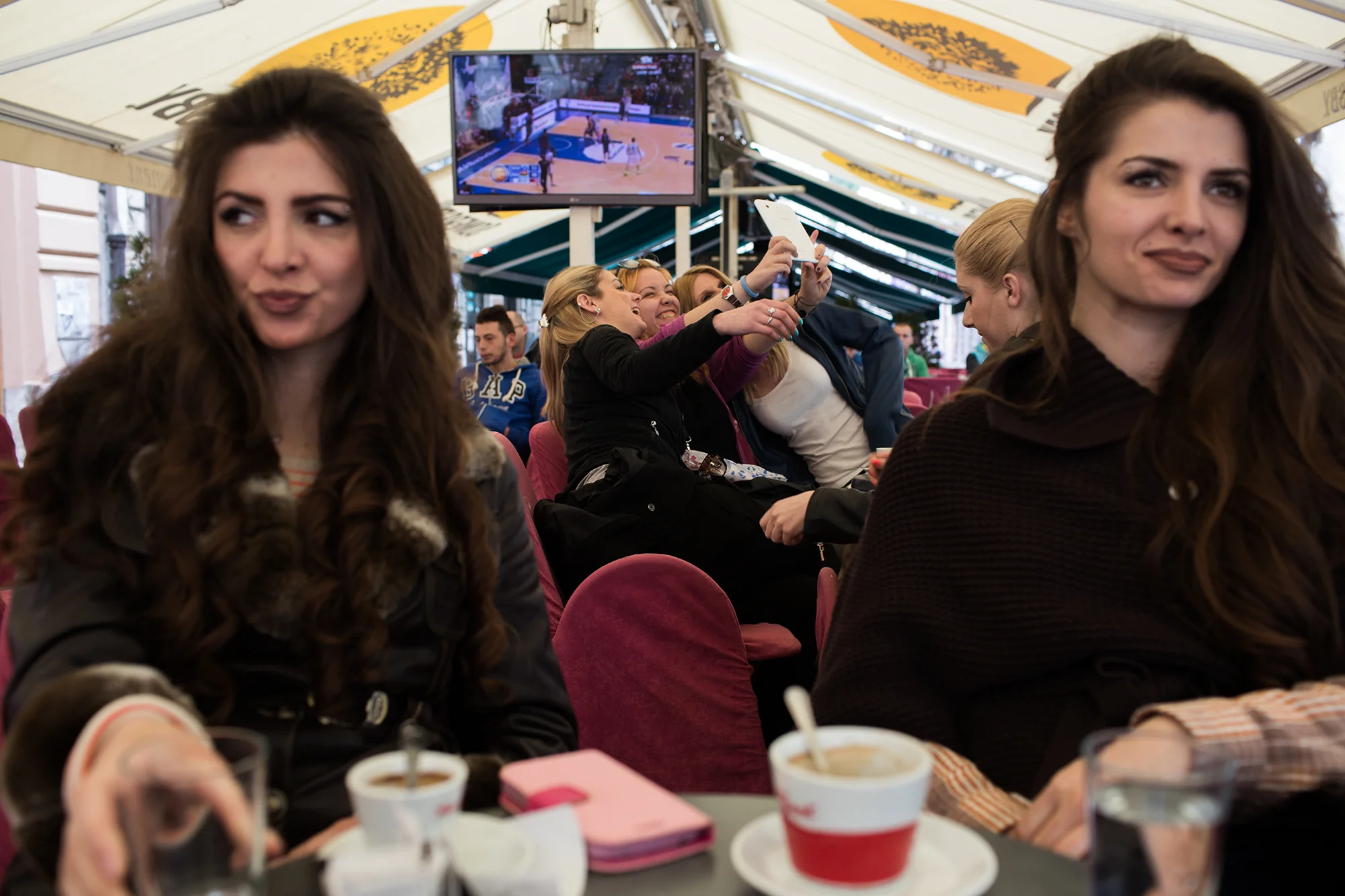Nizama Koldžo (left), a Bosnian Muslim, gets coffee before heading to a French class she is taking at the French Institute. She has been unable to find work since finishing her masters degree at a university in Brussels, despite being the first Bosnian to be accepted to that university for their masters. Her twin sister, Nermana (right), recently found employment, so Nizama is left continuing to search while her twin sister, from whom she says she is inseperatable, goes into work.