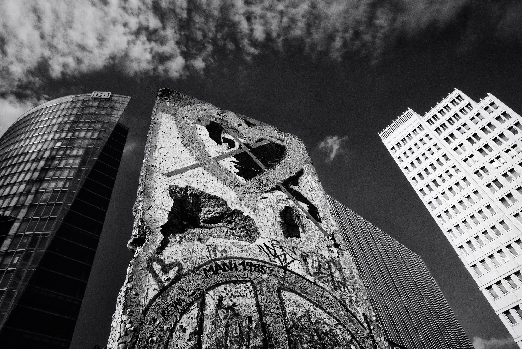 POTSDAMER PLATZ A section of the Berlin Wall stands below modern office buildings in Potsdamer Platz. The area was completely leveled during WWII and left desolate during the Cold War after it was divided by the Wall. Potsdamer Platz was a curiosity to Westerners, and several notable figures visited the area, including presidents John F. Kennedy, Jimmy Carter and George H.W. Bush. On November 9, 1989, the Wall was breached at Potsdamer Platz among several other locations. Potsdamer Platz is now one of the most modern centers for business and commerce in Europe and has had millions of dollars poured into its reconstruction. The crossed-out portrait on the wall is of Rosa Luxemborg, a Marxist and revolutionary for the Communist Party in Germany in the early 1900’s. 