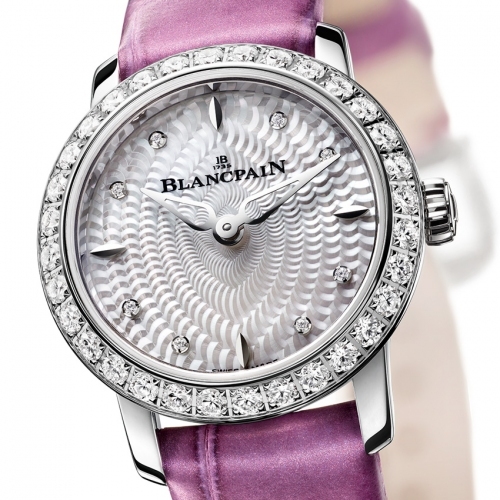 © Blancpain / swisstime.ch BLANCPAIN Ladybird Ultraplate Blancpain greift die bezaubernden Linien der Ladybird in einer zeitgemäss extraflachen Variante auf. Als sie 1956 vorgestellt wurde, war sie damals mit dem kleinsten runden Werk ausgestattet, das auf dem Markt verfügbar war. Sechzig Jahre später dokumentiert sie mit ihrer schlanken, von den Diamanten zusätzlich betonten Weissgoldsilhouette das überlegene stilistische Können und das technische Savoir-faire des Hauses Blancpain. Unter dem Glamourglanz der Uhr tickt heimlich ein winziges Werk mit automatischem Aufzug. Seine Hemmpartie ist mit einem Silizium-Spiral ausgestattet. Ein mechanisches Juwel. Gleichermassen filigran wie präzis. Auf dem Zifferblatt mit seinen vielen Perlmuttlagen findet die Zeit zum Licht und lenkt die Blicke auf sich. Eine behutsame Zeitreise zurück in die stilbewussten fünfziger Jahre. In einer limitierten Auflage von 60 Exemplaren. www.blancpain.com