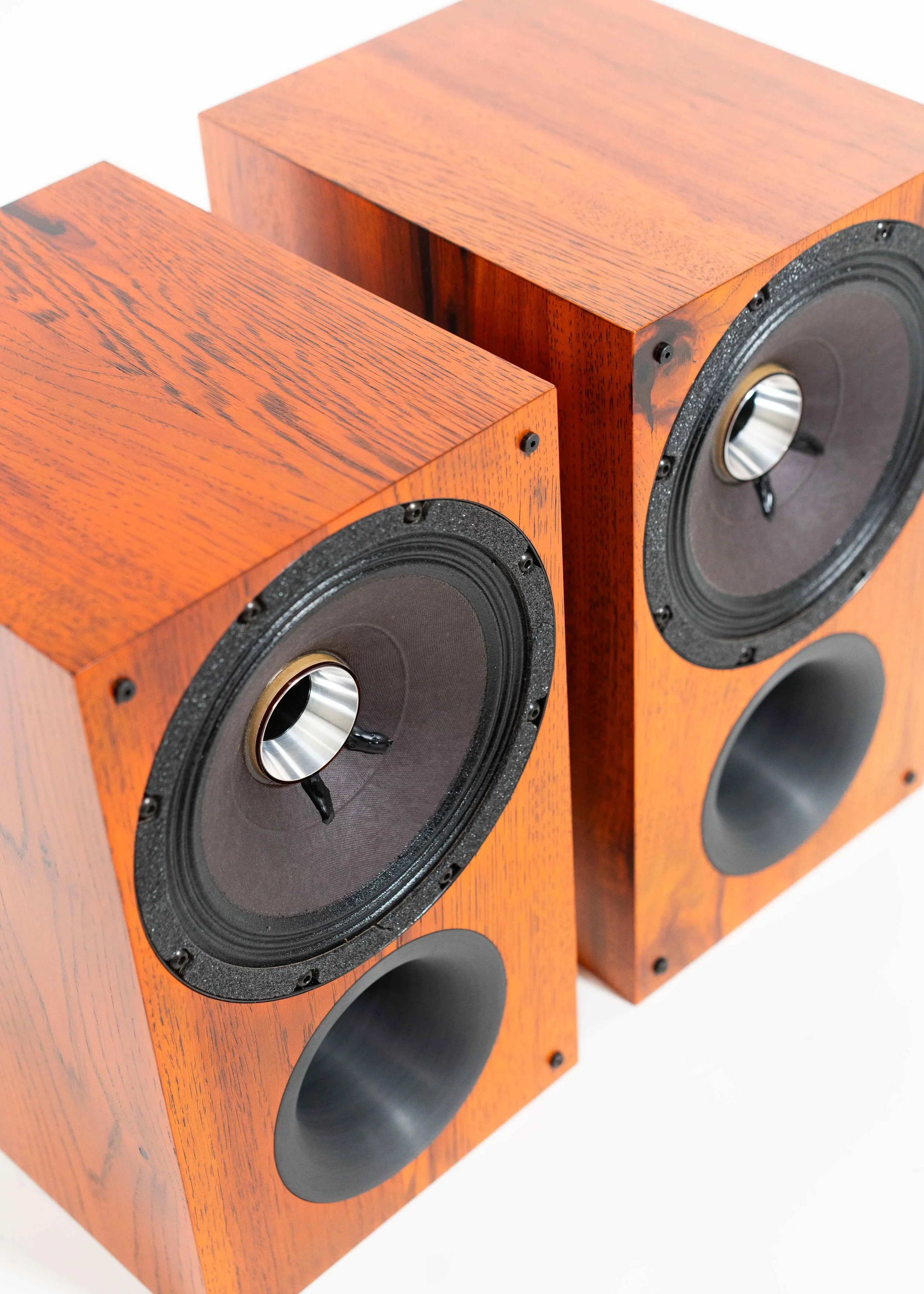 Closeup photo of Zu Method Bookshelf pair finished in custom ember orange candy over rustic hickory.