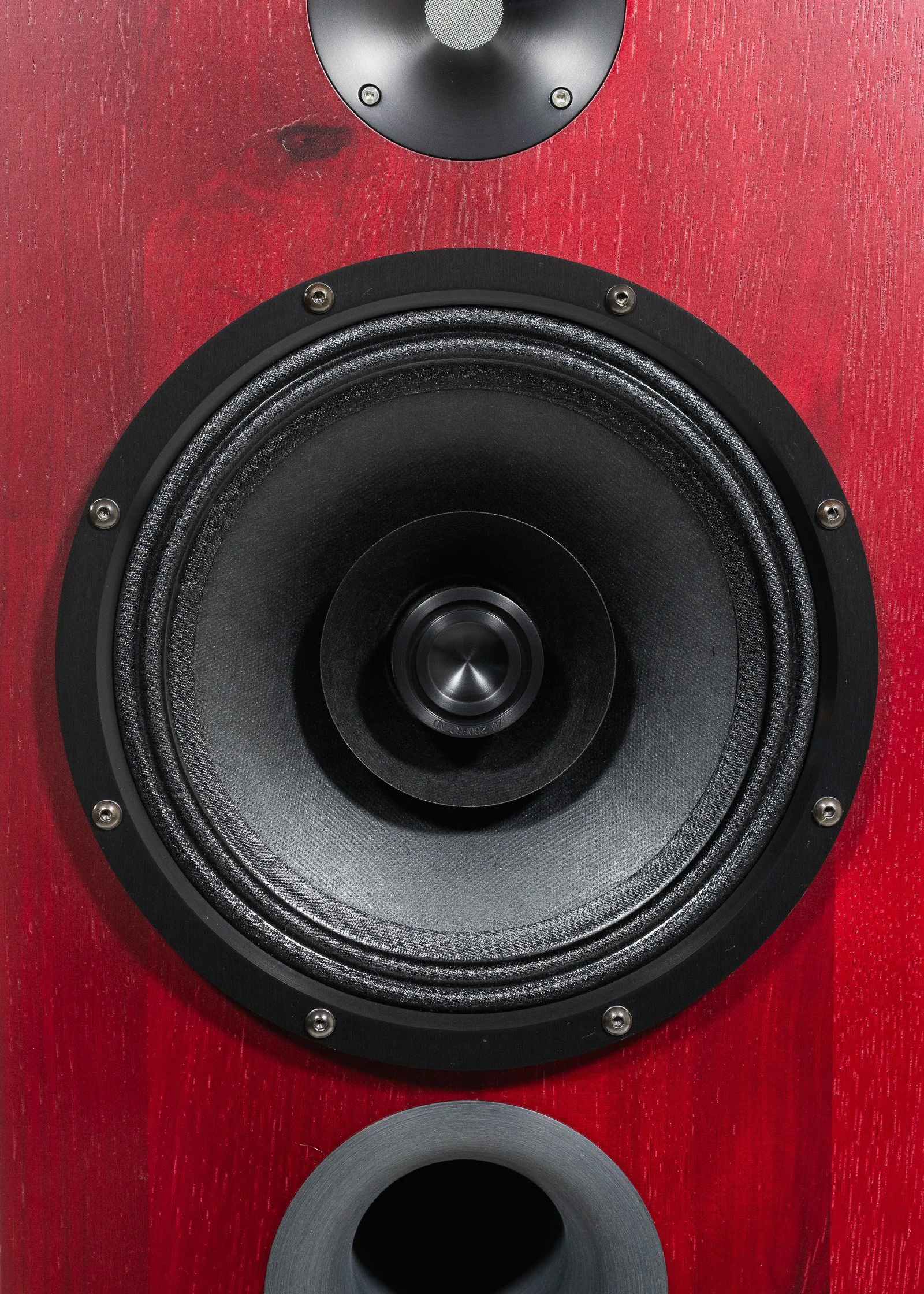 Closeup photo of Zu DWX loudspeakers finished in ruby red hickory and trimmed in black anodized hardware.