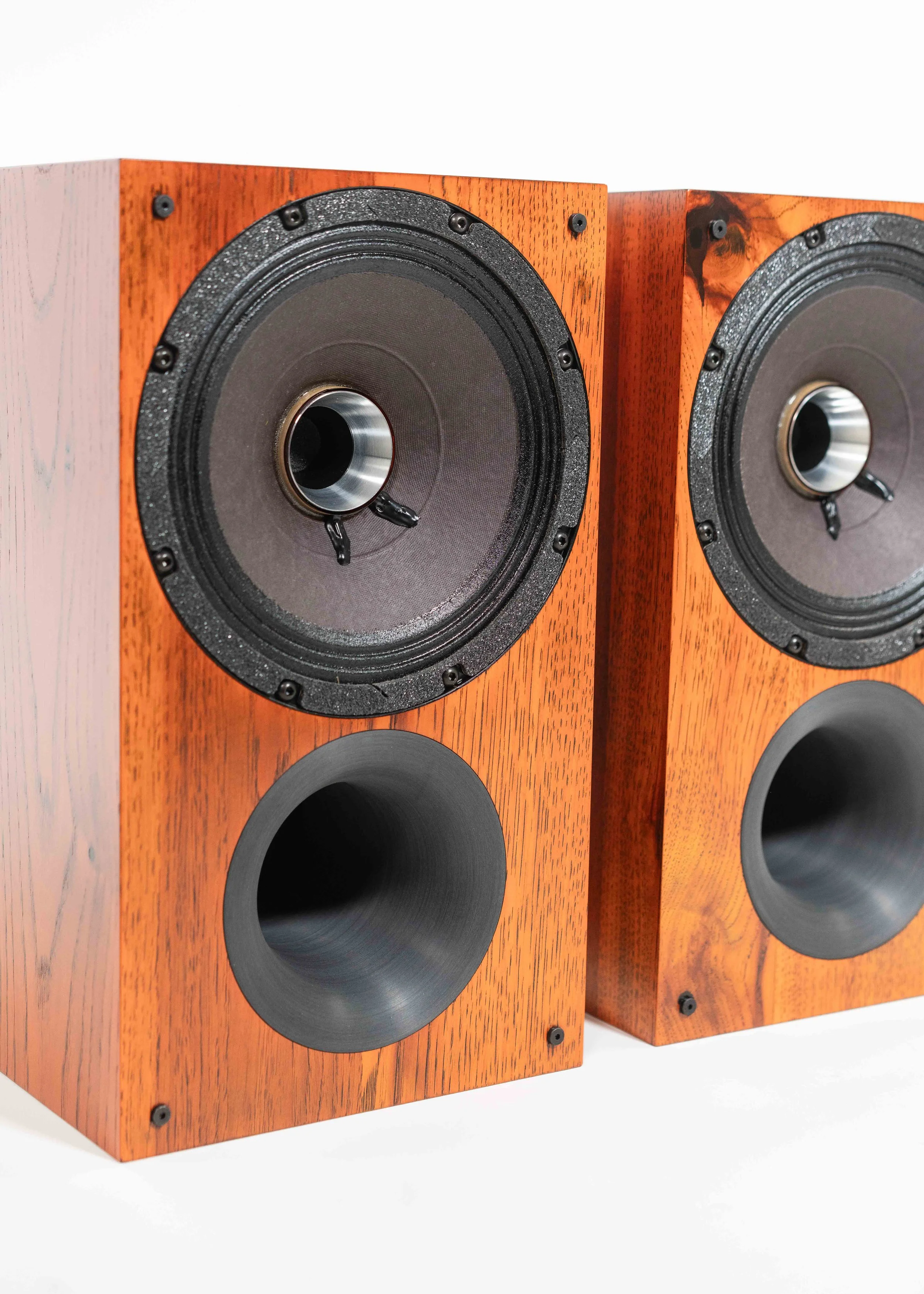 Closeup photo of Zu Method Bookshelf pair finished in custom ember orange candy over rustic hickory.