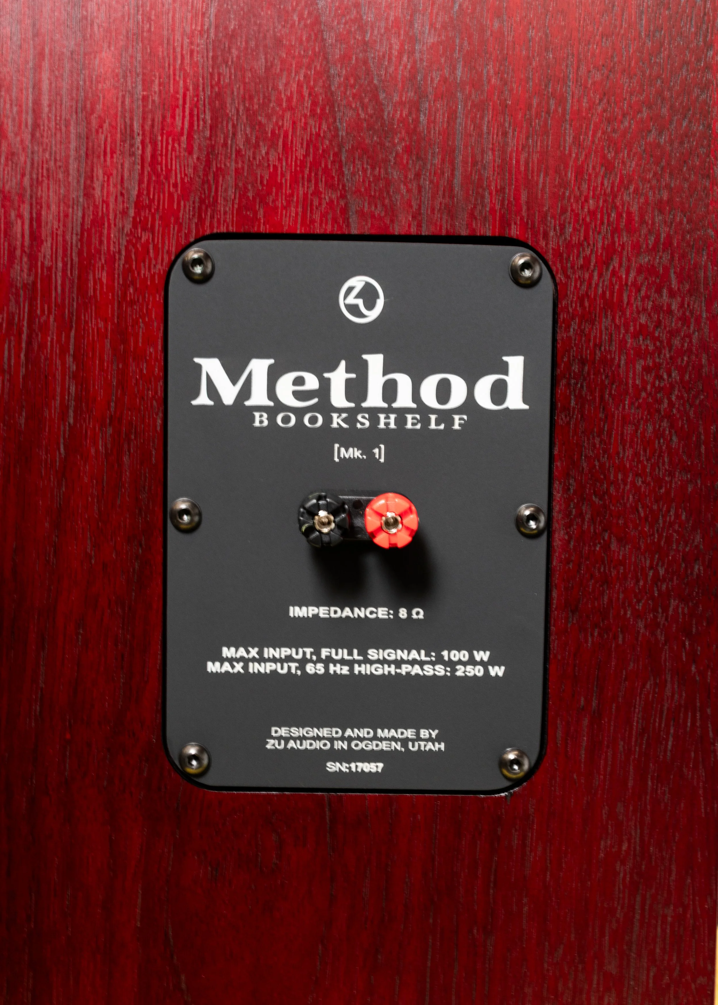 Nameplate photo of Zu Audio Method Bookshelf speakers, finished in black filled grain and then candy red.