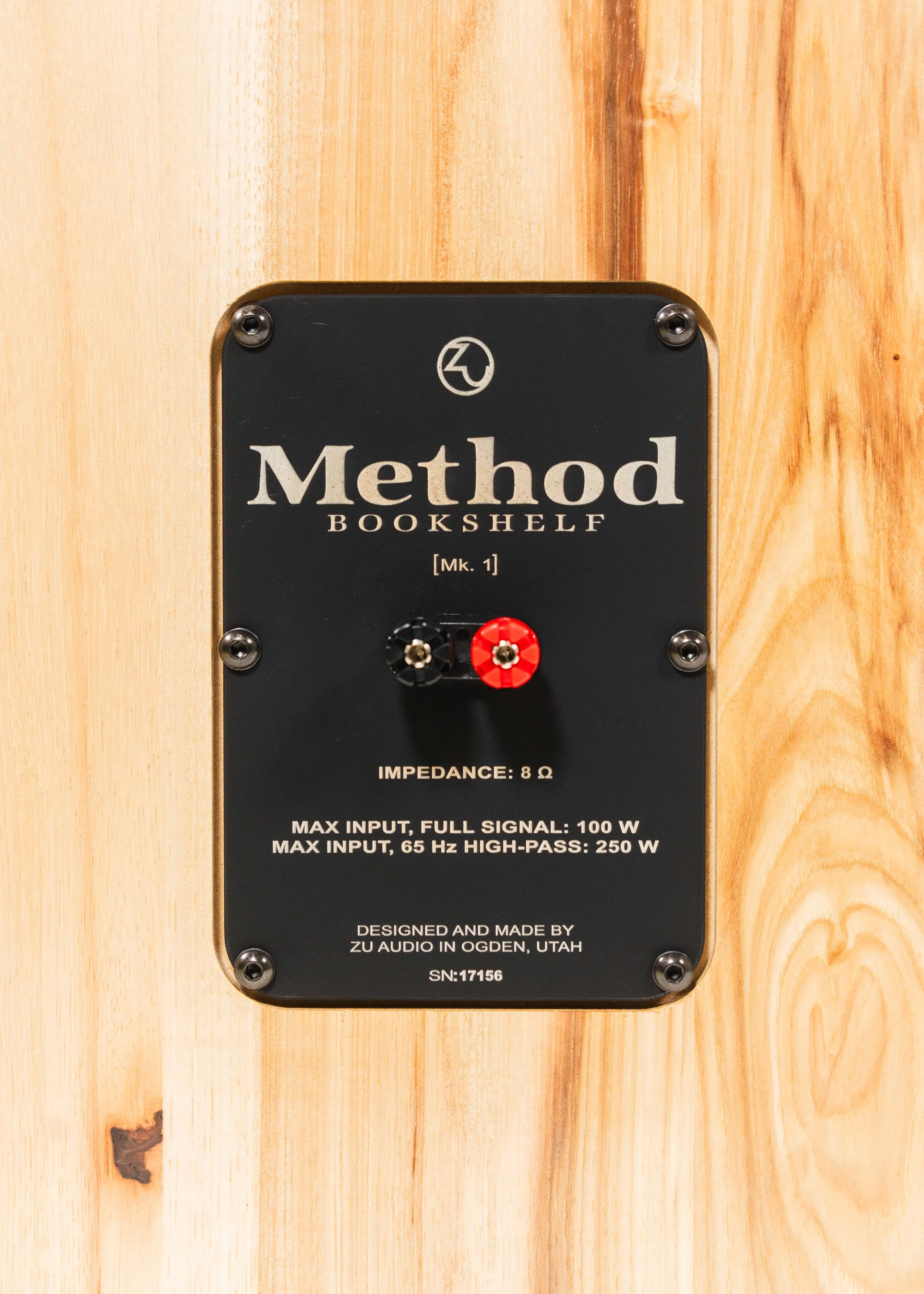 Nameplate and connector photo of Zu Method Bookshelf speakers finished in rustic hickory.