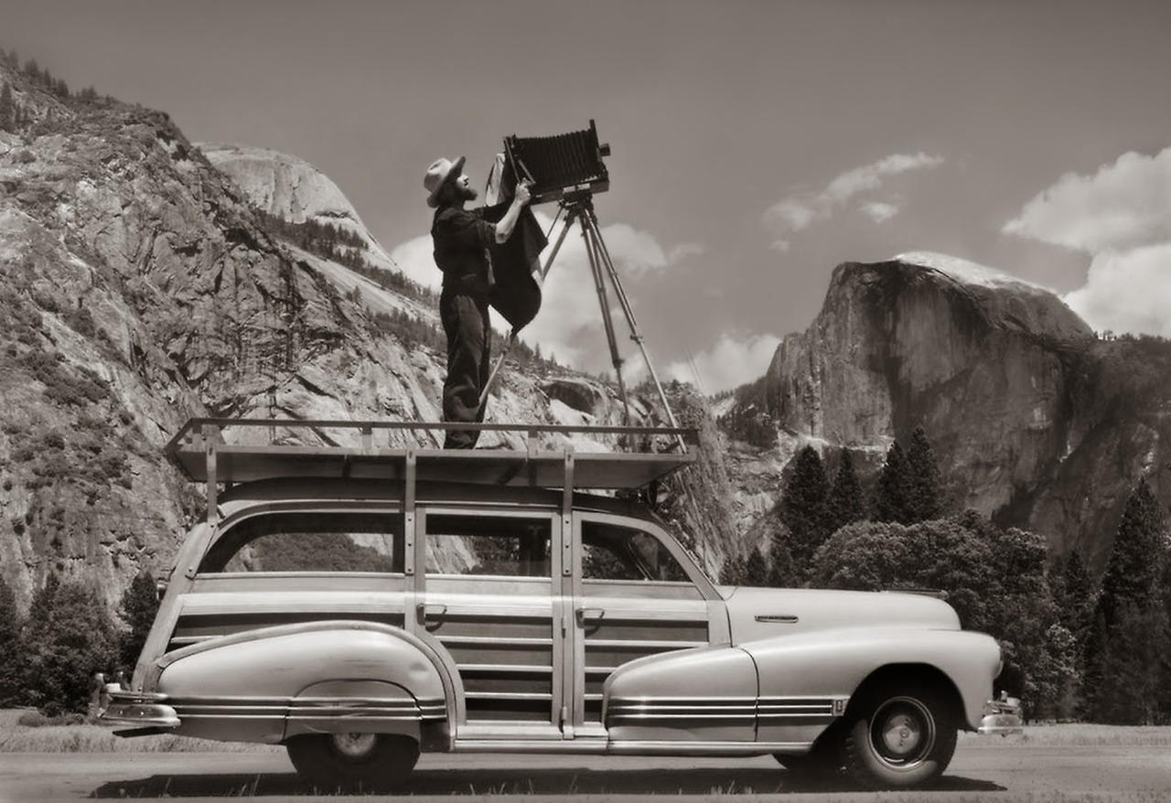 Ansel Adams, photographing in Yosemite National Park from atop his car about 1942.&nbsp;By Cedric Wright. Courtesy of the Cedric Wright Family