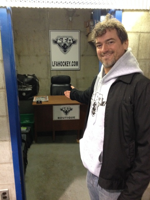 Le prez de la ligue montre fièrement son nouveau bureau à l'aréna (photo par Larry)