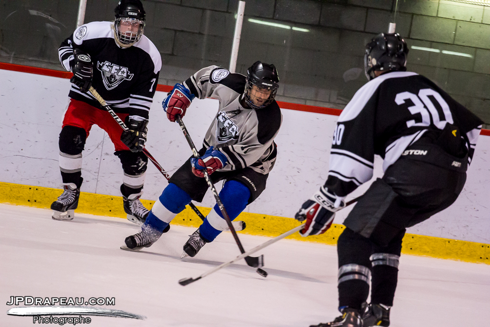 The rookie, Benoit Des Roches from the Czechers, swirling around against two opposing players from the Loggers.