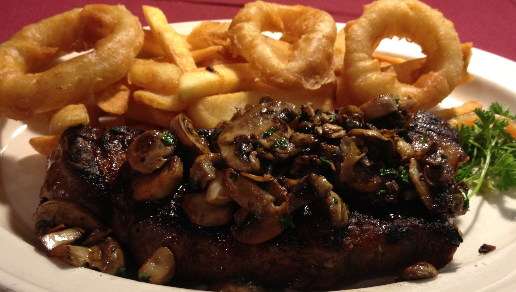 Grilled ‘Quiet Man’ Sirloin Strip Steak (15 oz.)...Sautéed Mushrooms,  Steak Fries, and Onion Rings