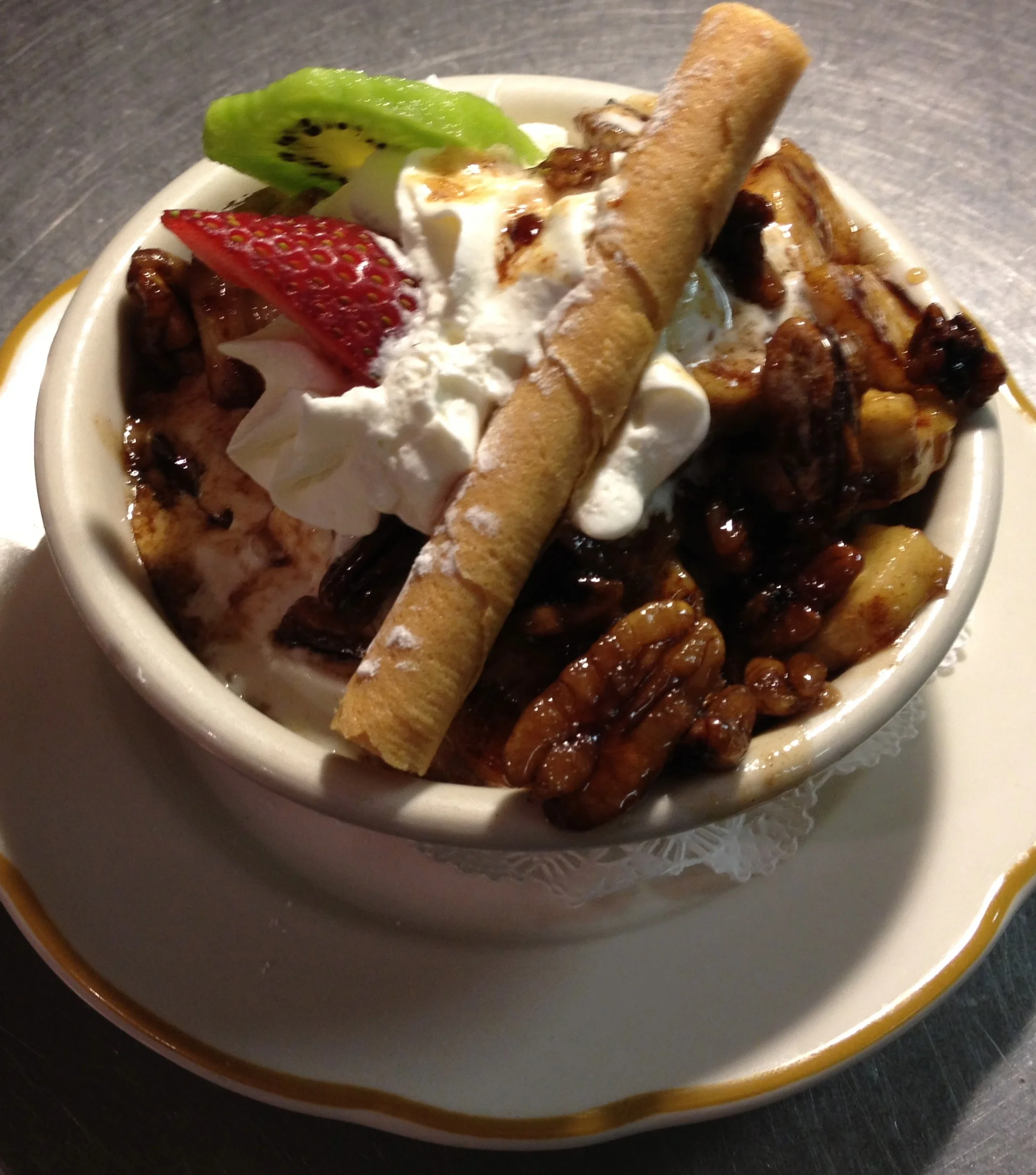 Bananas in Warm Banana Liqueur, Pecans, Brown Sugar and Butter Sauce over Butter Pecan Ice Cream