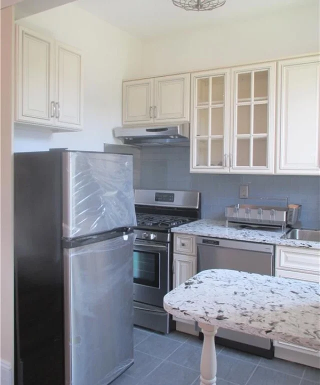 Before shot of our kitchen (plastic still on the fridge and everything). 