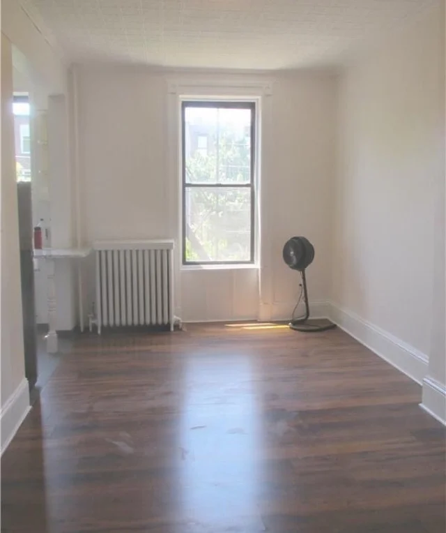 Shot of the living room standing in the office doorway. Kitchen is in the left back corner. 