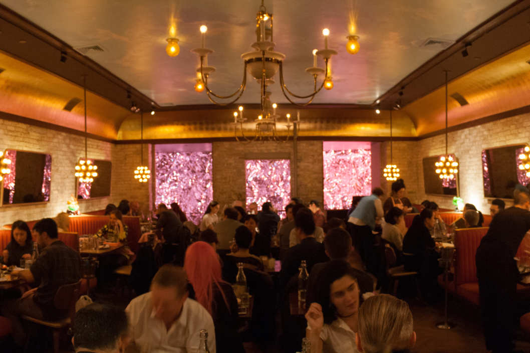 A foil wall dazzled with pink light provides a wild and fun backdrop to the main dining room. (Photo Credit: Grub Street)