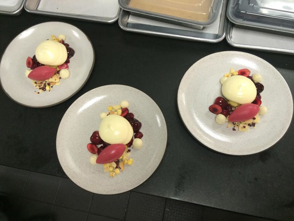 Plating the Corn and Cherry dessert for guests in the dining room.
