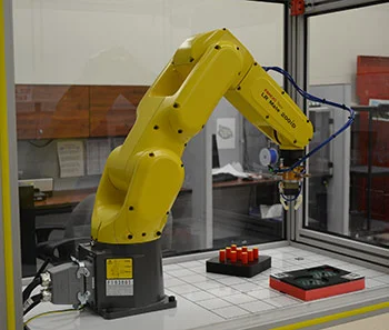 Robot challenged to demonstrate its dexterity on NIST test artifacts. The new ARIAC competition will focus on agility—how well robots can perform a diverse set of tasks and how quickly they can be re-tasked.Photo Credit: NIST/D. Russell
