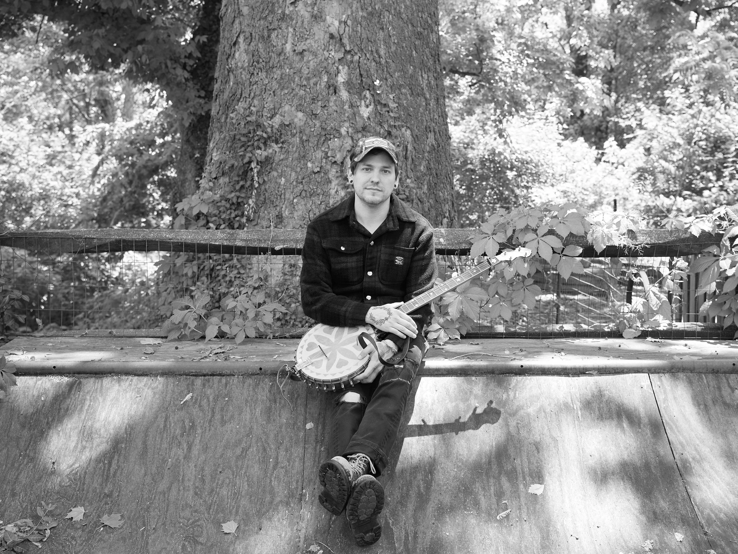 A photograph of a person holding a banjo.