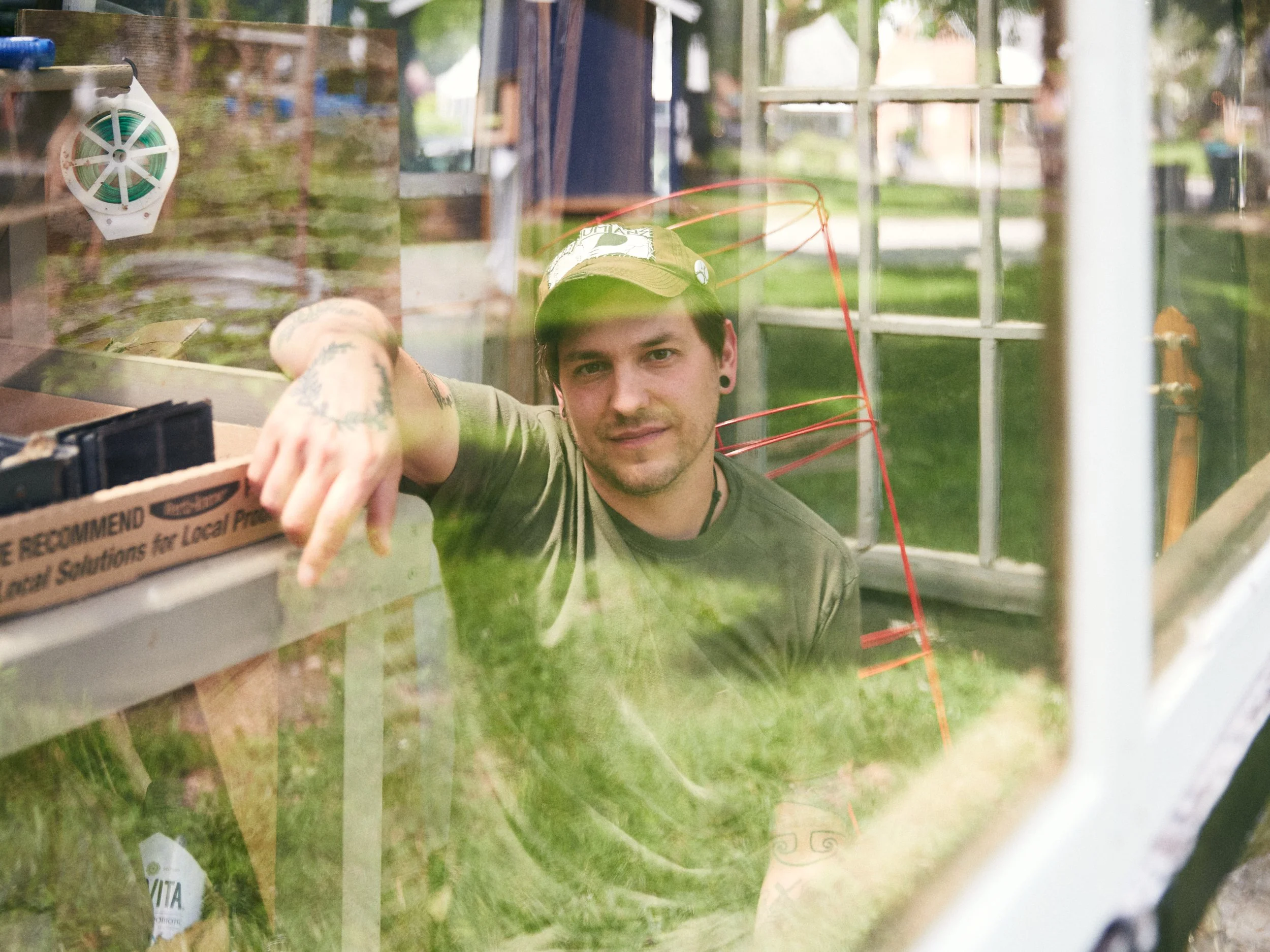 A photograph of a person inside of a greenhouse.