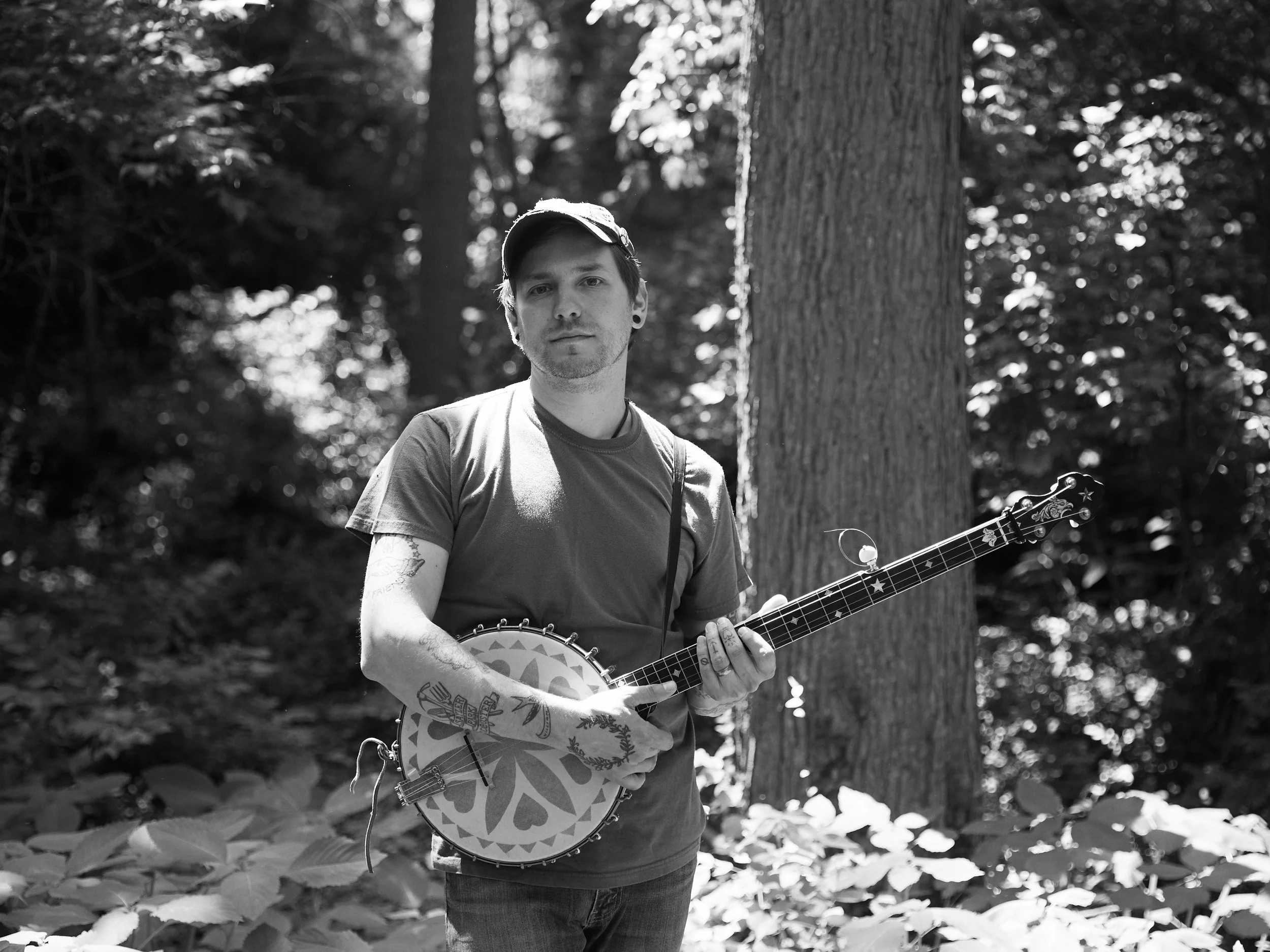 A photograph of a person holding a banjo.
