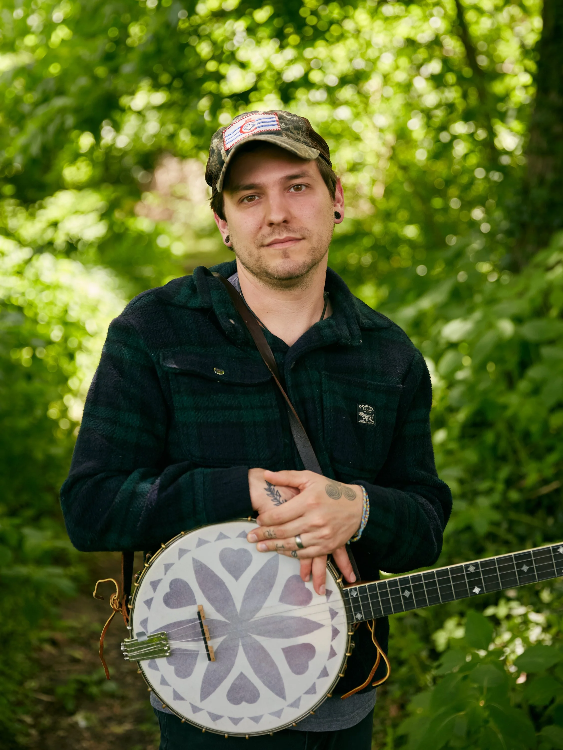 A photograph of a person holding a banjo.