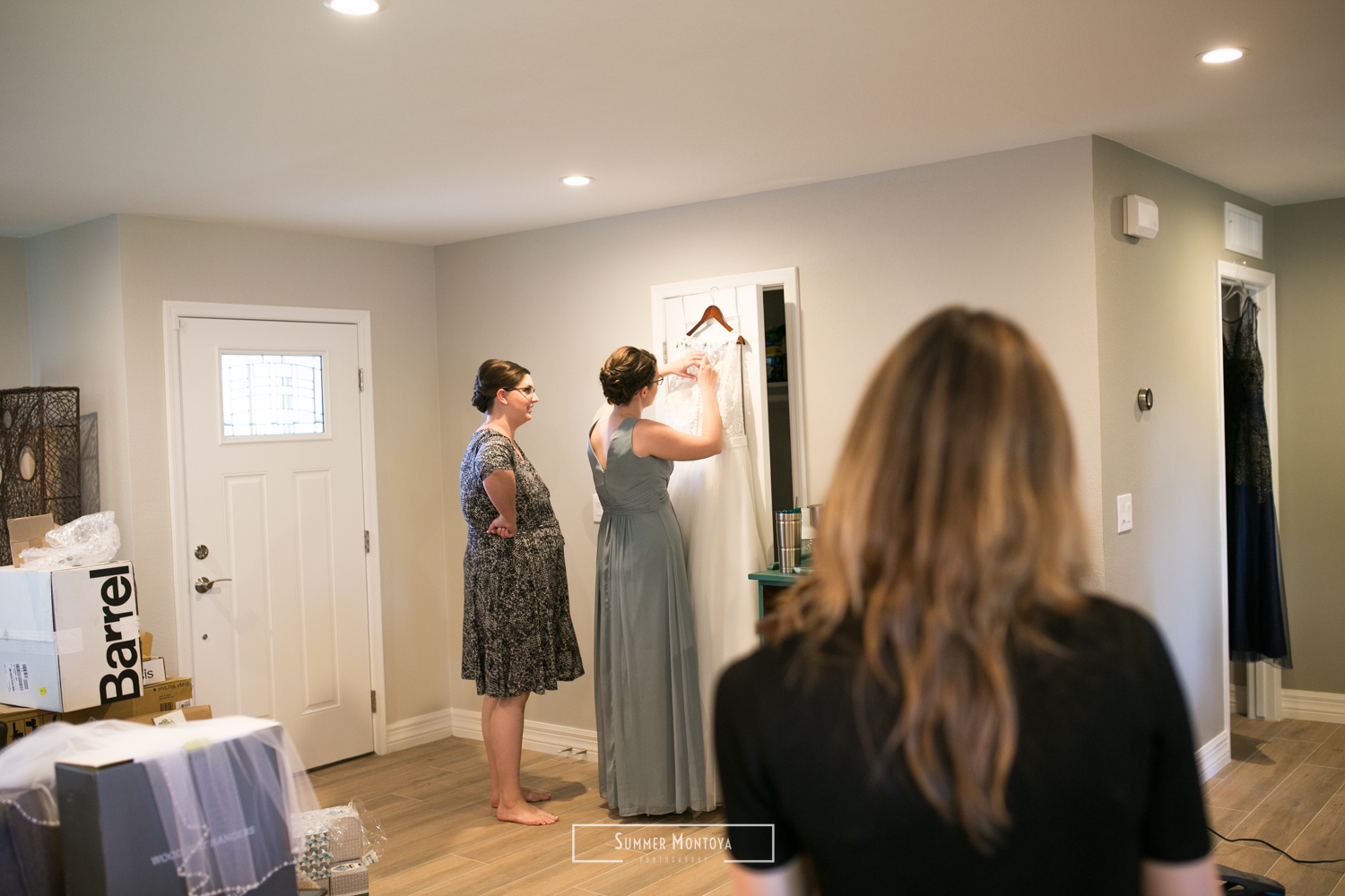  Bride and sister adjusting wedding dress 