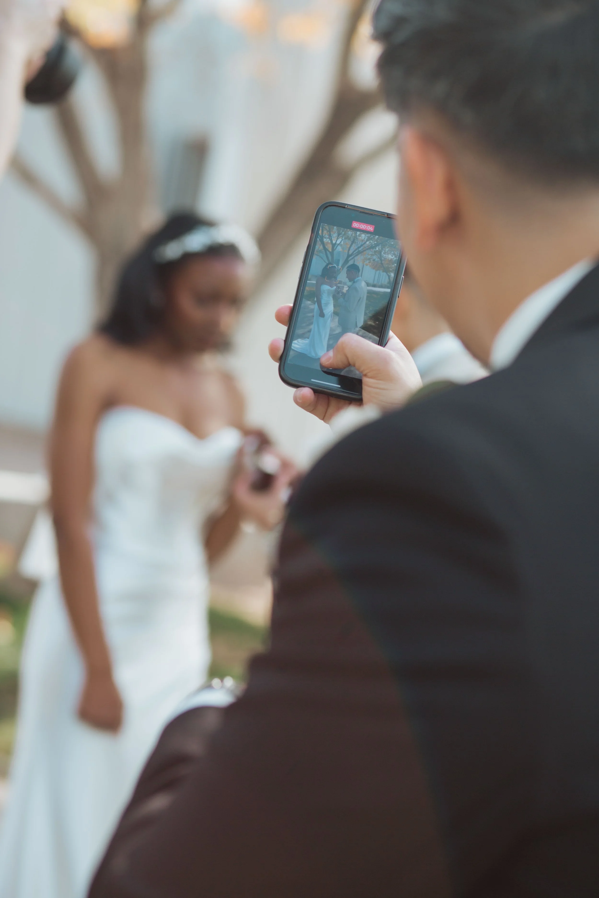 Best man taking a photo of the couple with his cell phone