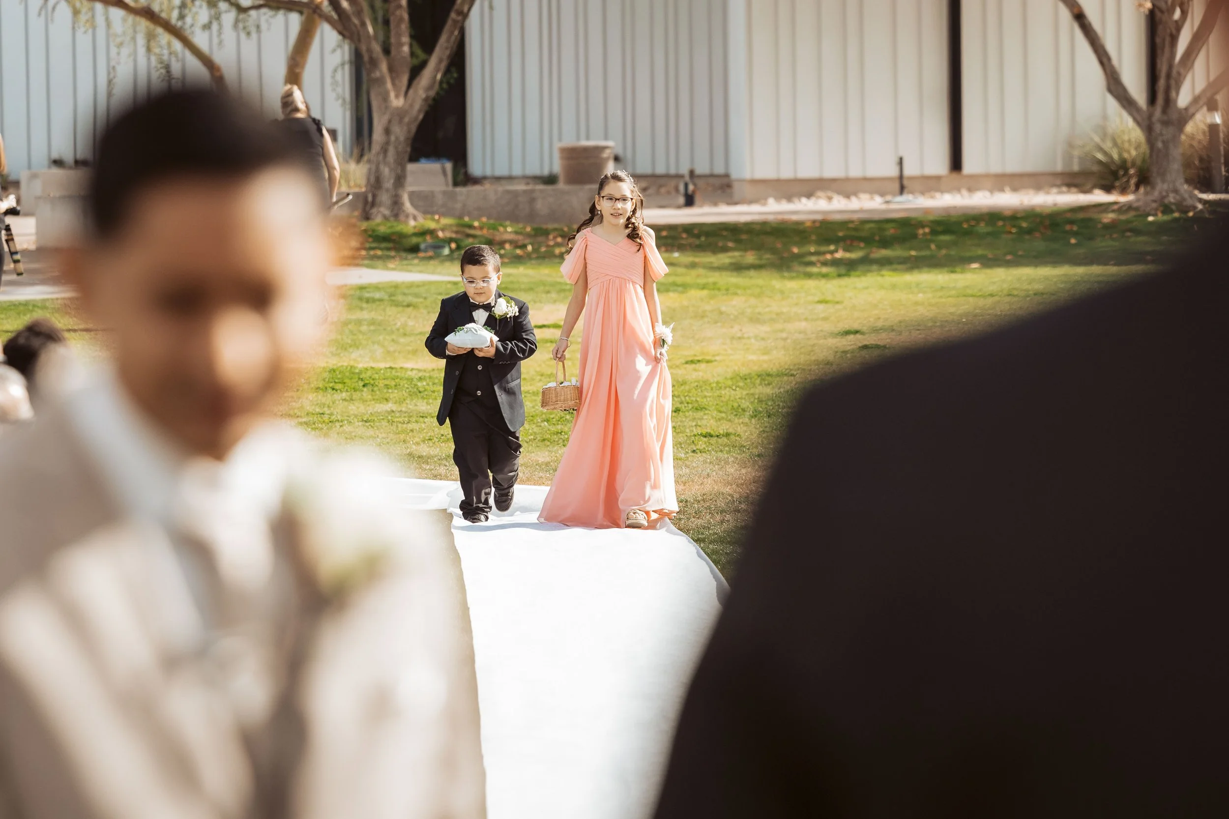 Ring bearer and flower girls walking down the aisle in Gilbert