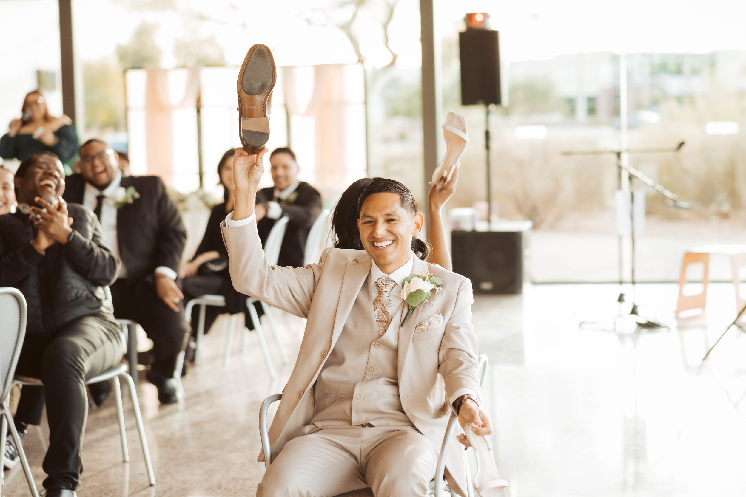 Groom playing shoe game at reception in Gilbert