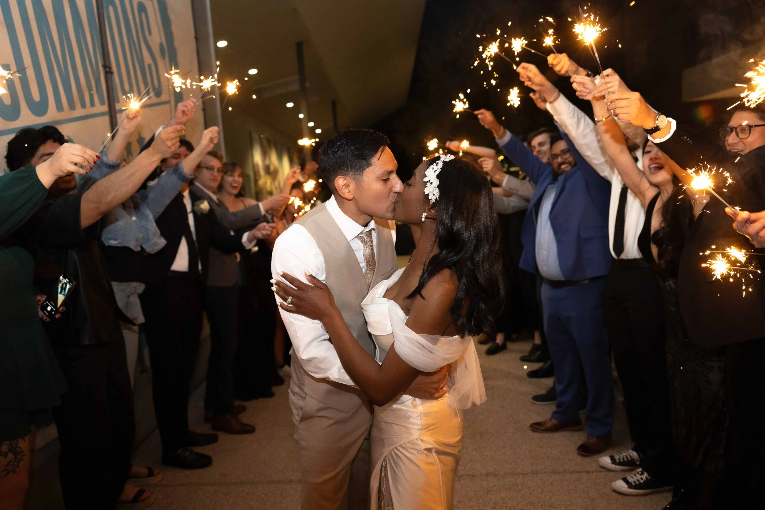 Bride and groom kissing during sparkler exit at reception in Gilbert