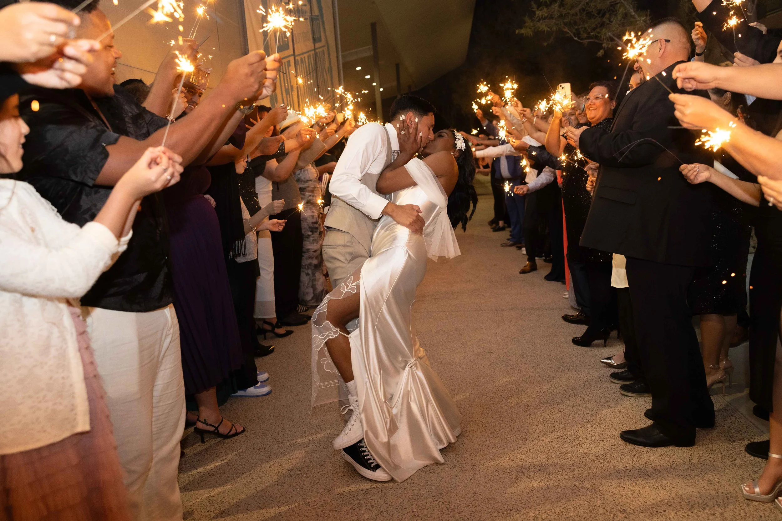 Bride and groom kissing during sparkler exit at reception in Gilbert