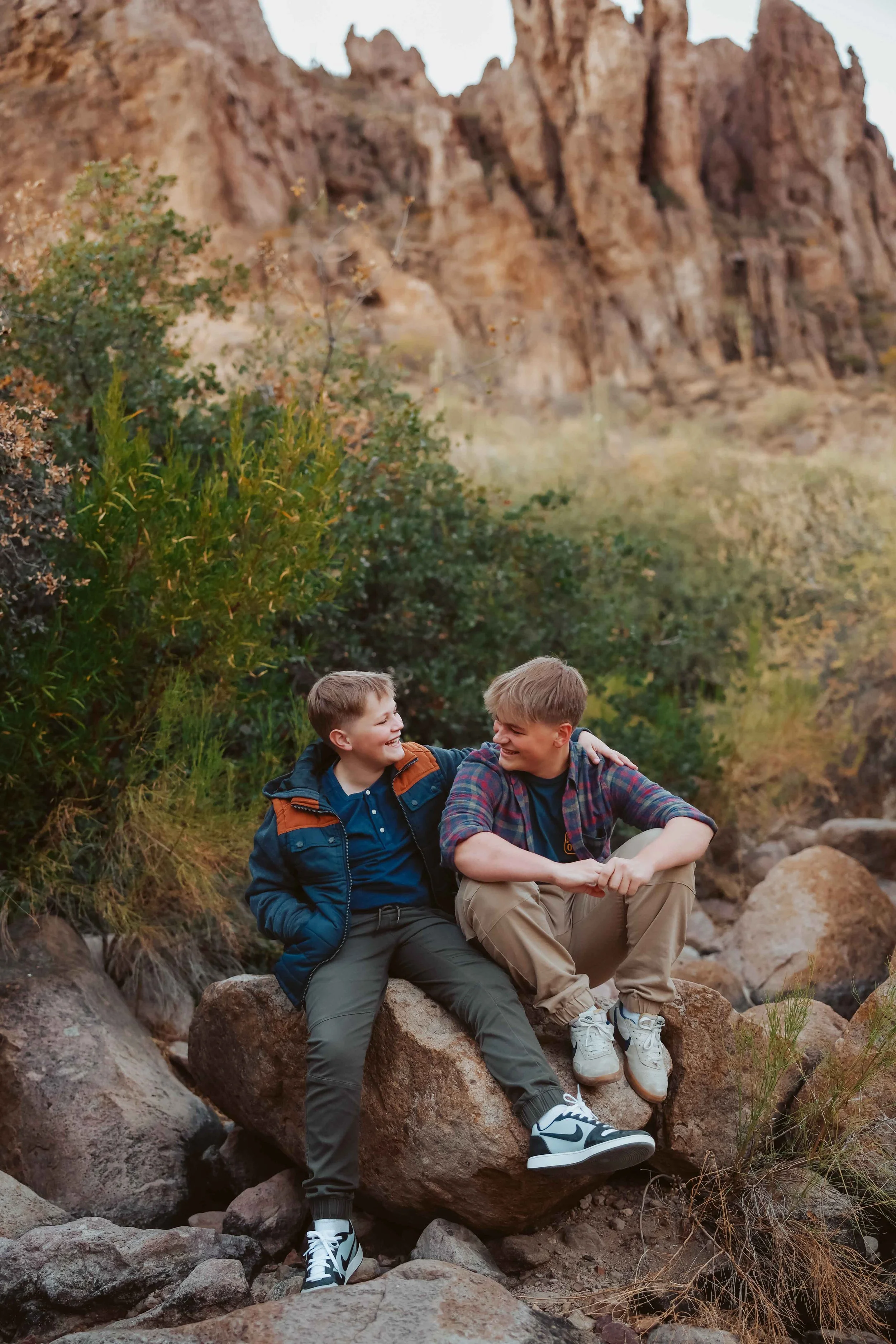 Two boys sitting on rocks at Arizona desert during family session
