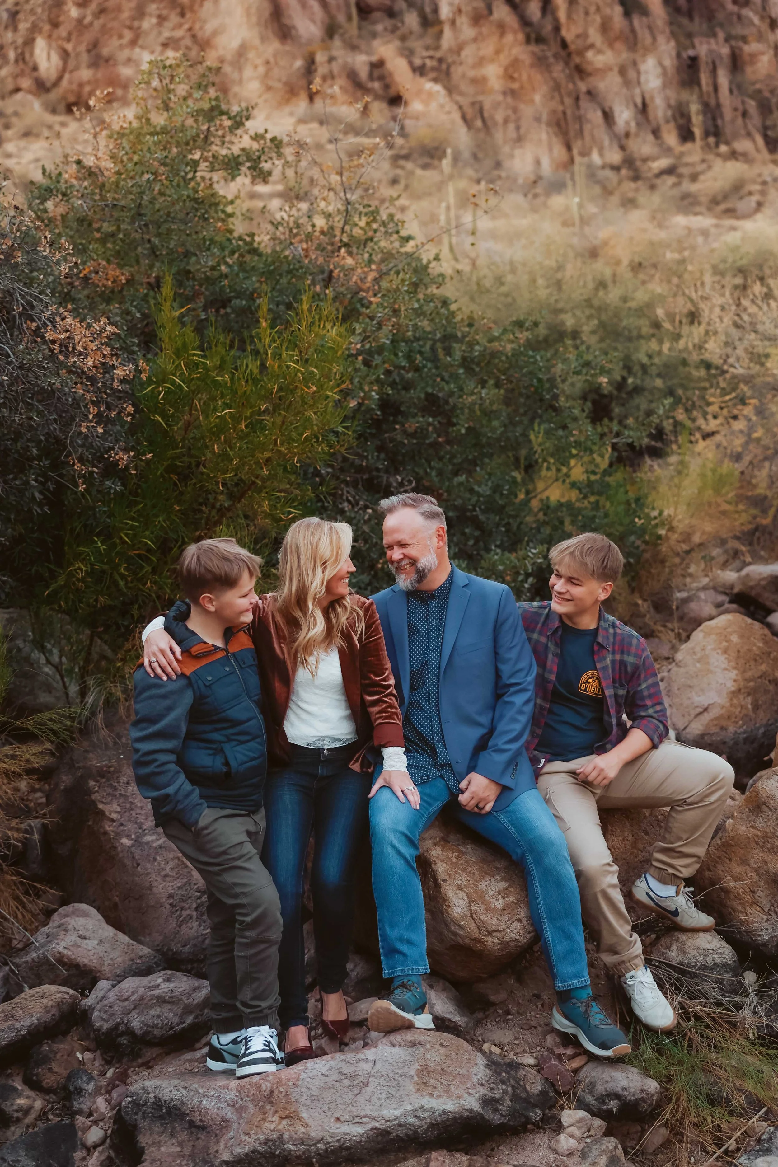 family of four sitting on rocks in the superstition mountians
