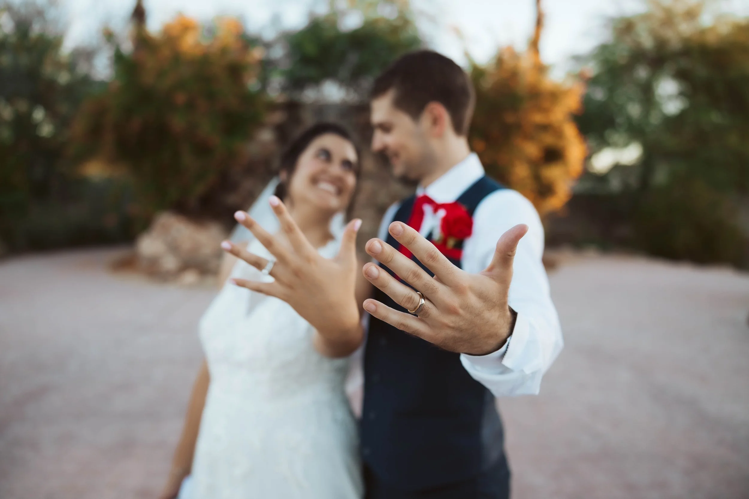 Close up of wedding rings with couple in the background