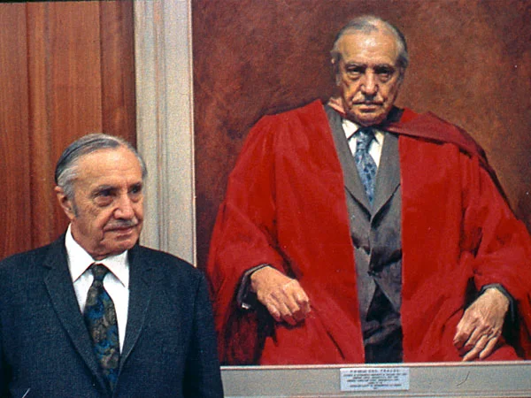 Dr P R Begg alongside a portrait of himself.