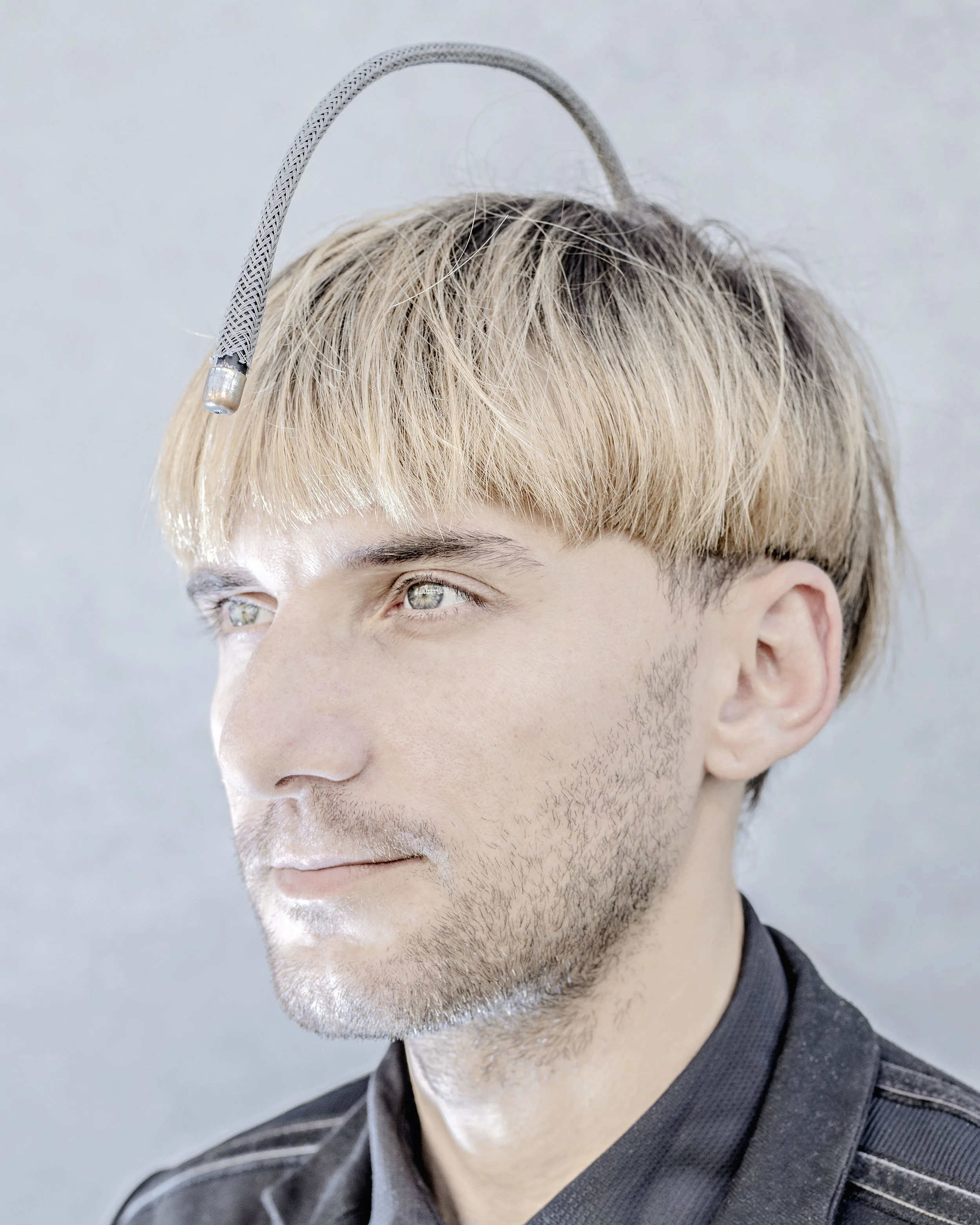 Matthieu Gafsou. Neil Harbisson considers himself a cyborg. Suffering from achromatopsy, a rare form of color blindness, he had a prosthesis called Eyeborg implanted into his skull that senses colors and converts them into sound waves. Harbisson pleads for the enhancement of human creativity and sometimes distances himself from transhumanism, deeming it too stuck in stereotyped or commercial representations. His vision is more that of an artist than a disciple of technoscience. He takes pride in being the first human to appear with his prosthesis on his passport photo. Munich, July 15, 2015. Courtesy of the artist, Galerie C and MAPS.