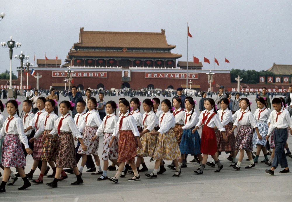 Bruno Barbey, ‘Tiananmen Square. School girls prepare for the reception of French president Georges Pompidou. In the background: Mao portrait and slogans “Long live the People's Republic of China. Long live the Union of the people of the world.”’ Beijing, China, 1973. © Bruno Barbey/Magnum Photos